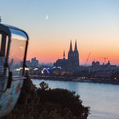 Eine Gondel der Kölner Seilbahn im Abendlicht mit Blick auf den Kölner Dom.