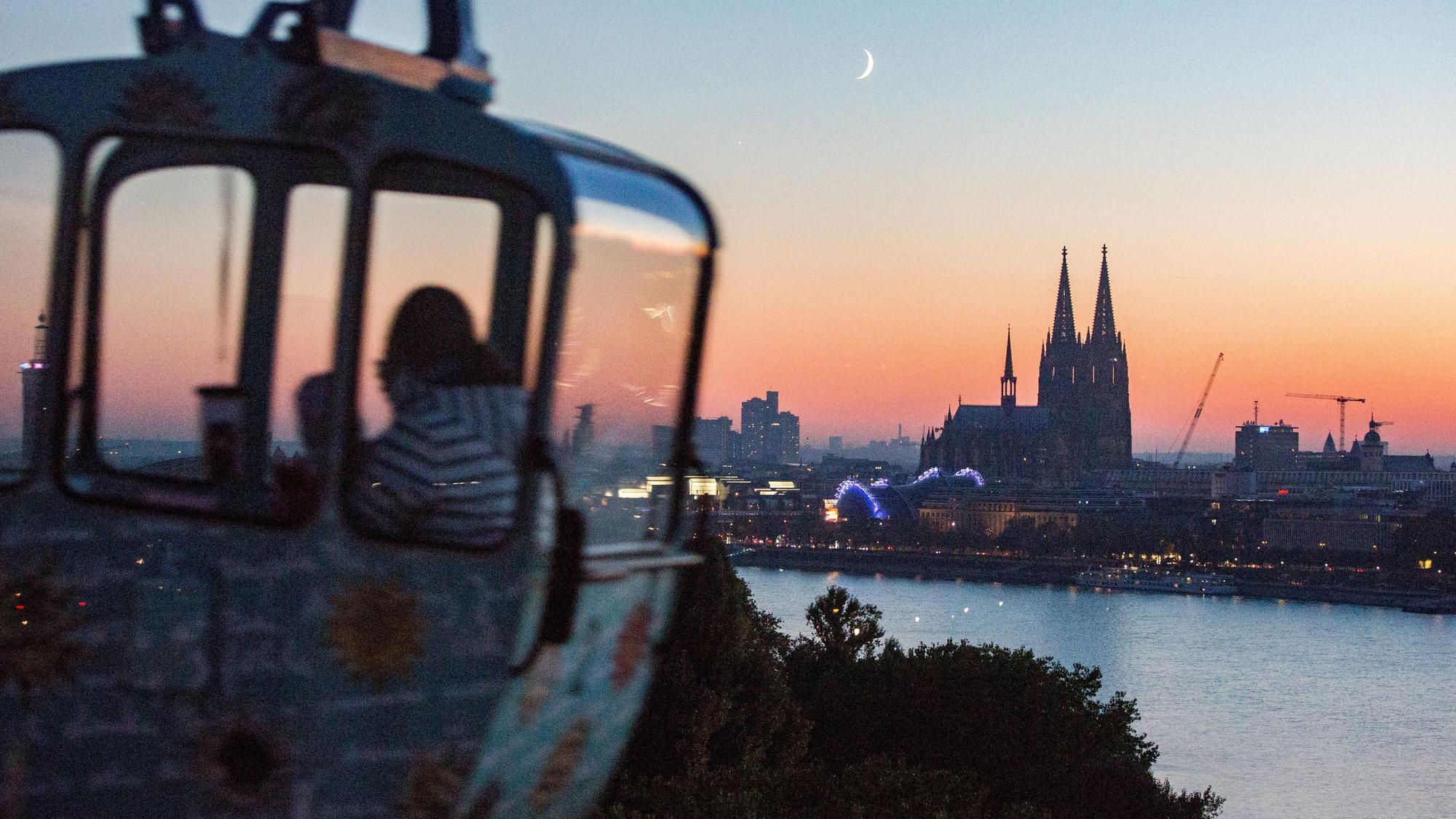 Eine Gondel der Kölner Seilbahn im Abendlicht mit Blick auf den Kölner Dom.