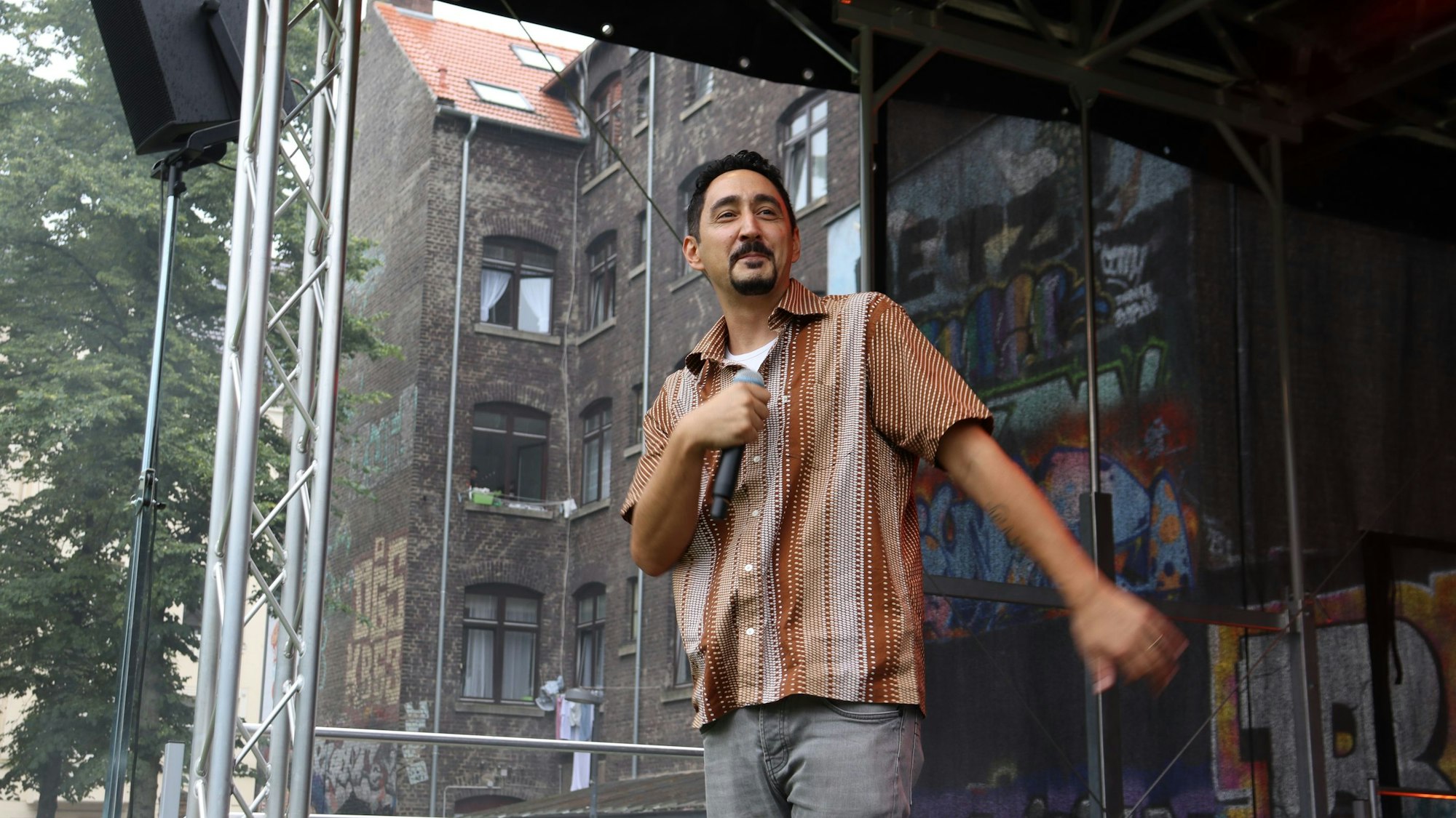 Rapper Eko Fresh steht auf einer Bühne und performt.