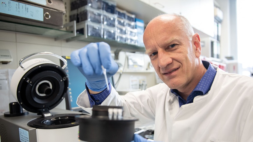 Ulf Dittmersteht im Labor vor einer Maschine.