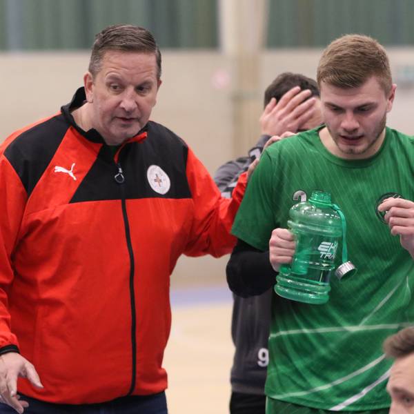 Das Bild zeigt Trainer Olaf Pohlmeier, wie er mit seinem Teil seiner Spieler spricht.