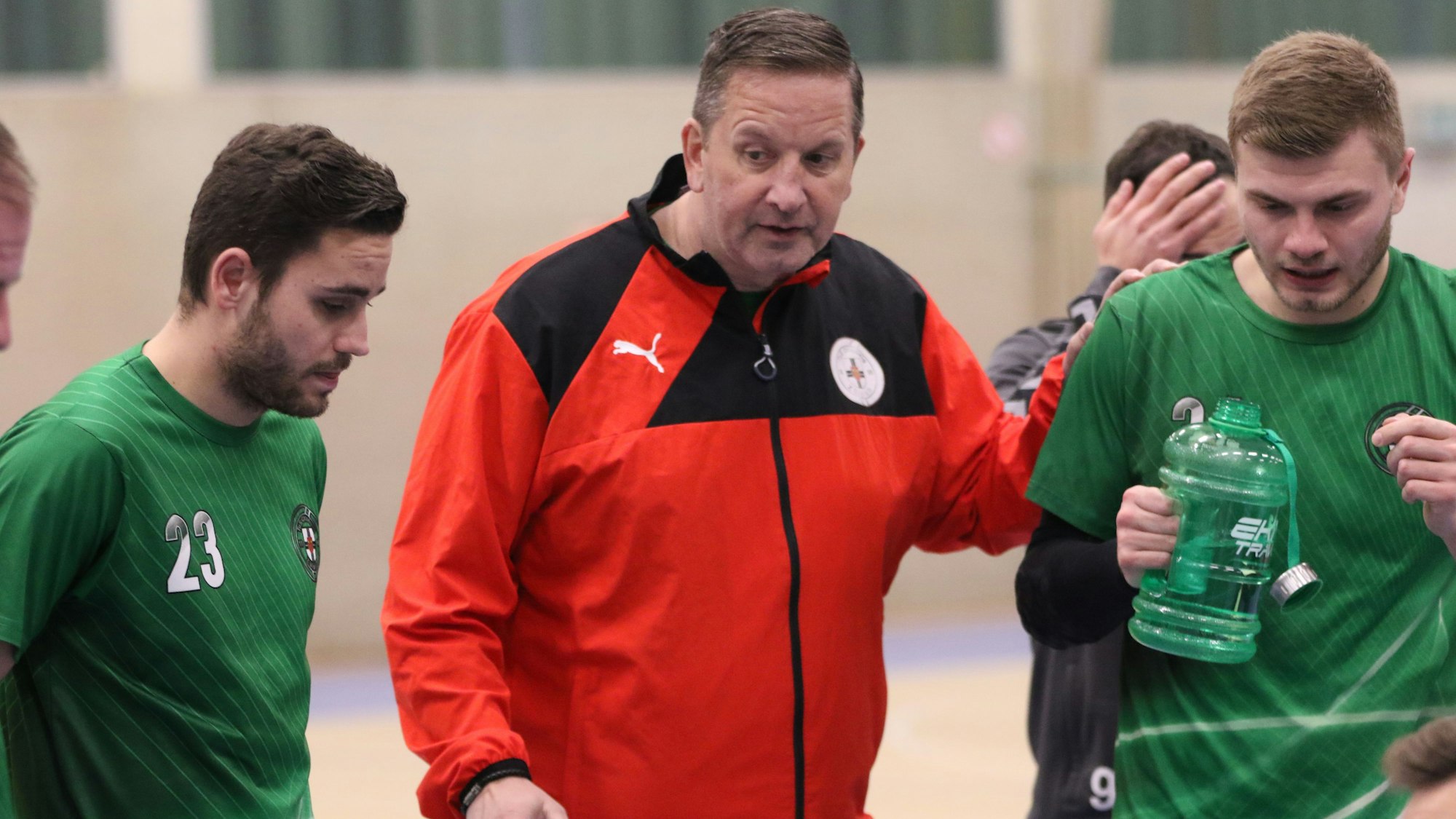 Das Bild zeigt Trainer Olaf Pohlmeier, wie er mit seinem Teil seiner Spieler spricht.