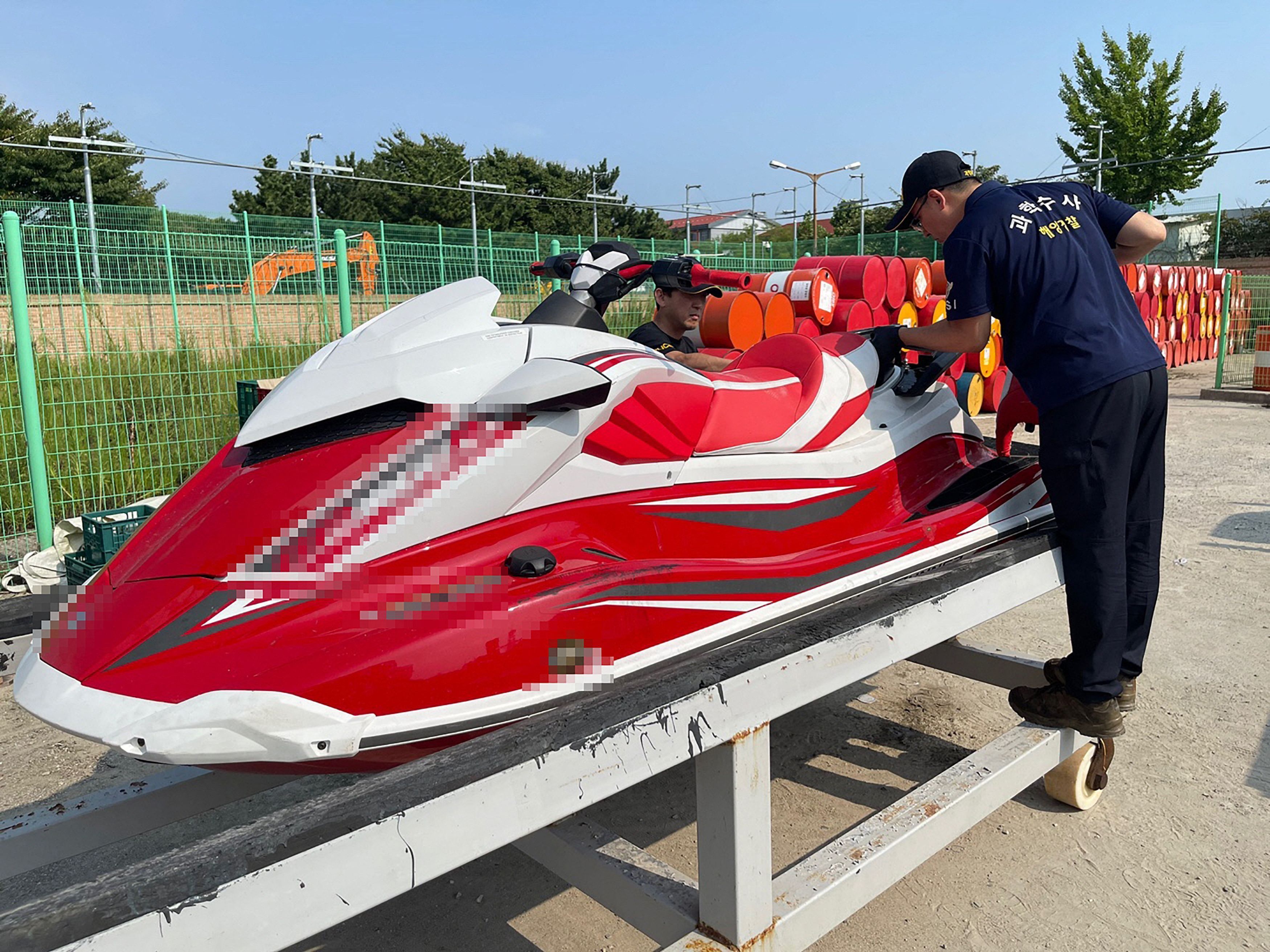 Ein undatiertes, von der koreanischen Küstenwache zur Verfügung gestelltes Handout-Foto zeigt zwei Mitarbeiter der Küstenwache, die sich einen Jetski in Incheon ansehen. Die Küstenwache bestätigte, dass sie einen Chinesen verhaftet hat, der letzte Woche versucht hatte, mit dem Jetski aus dem chinesischen Shandon in die westliche Hafenstadt Incheon zu schmuggeln.