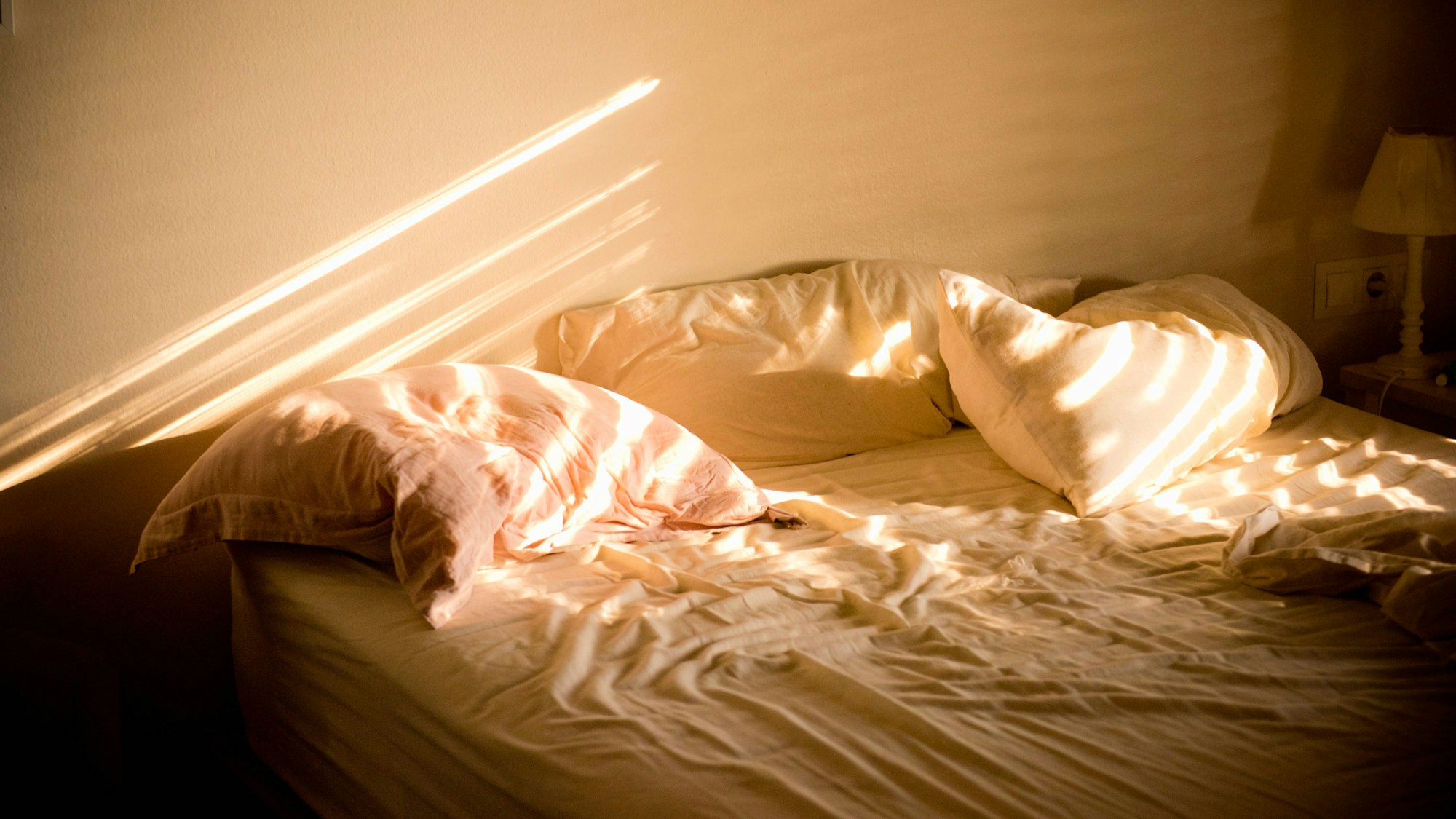 Bettwäsche liegt unordentlich auf einem Bett.