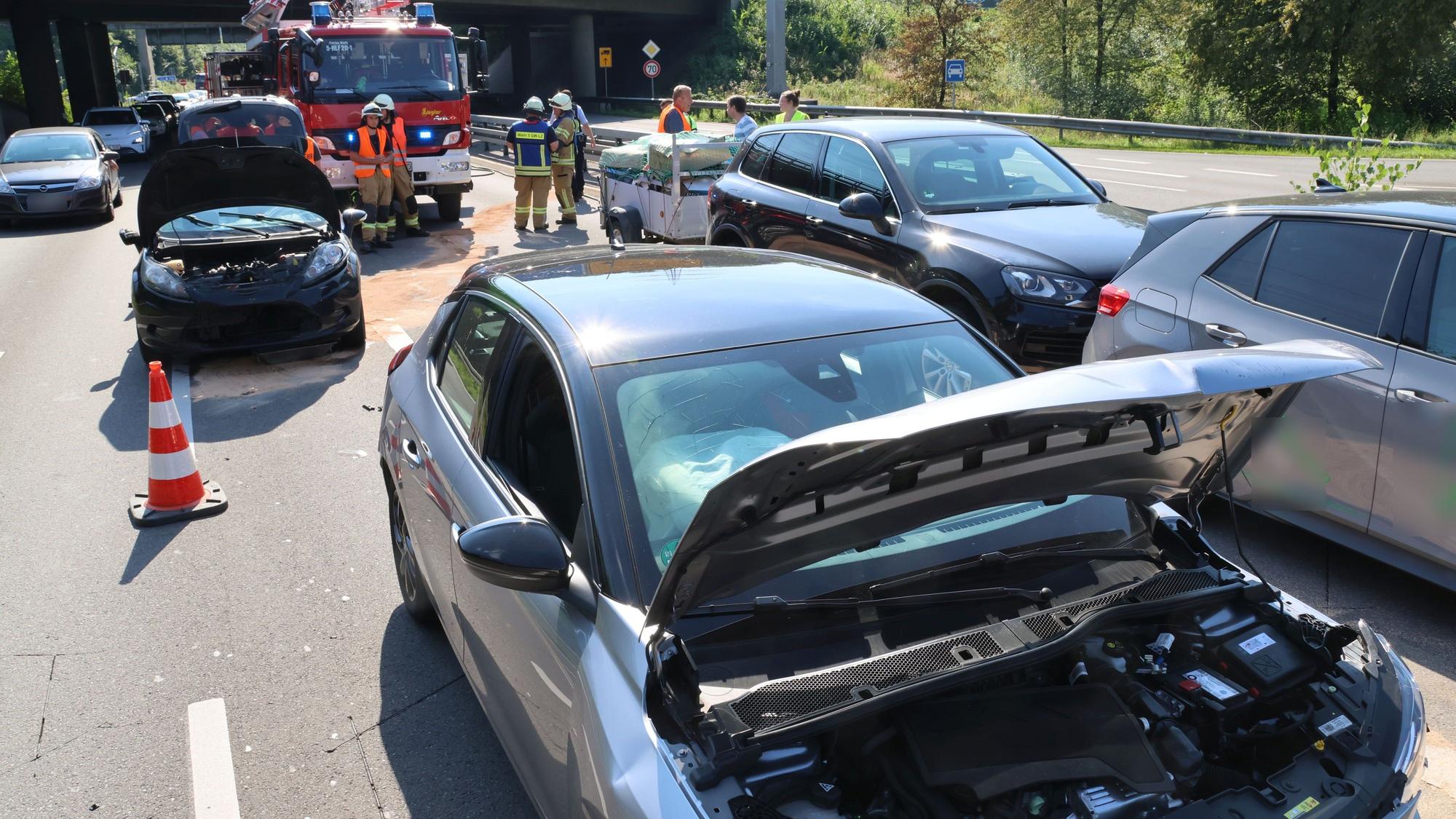 Mehrere beschädigte Autos stehen auf zwei Fahrspuren. Im Hintergrund ist die Feuerwehr zu sehen.