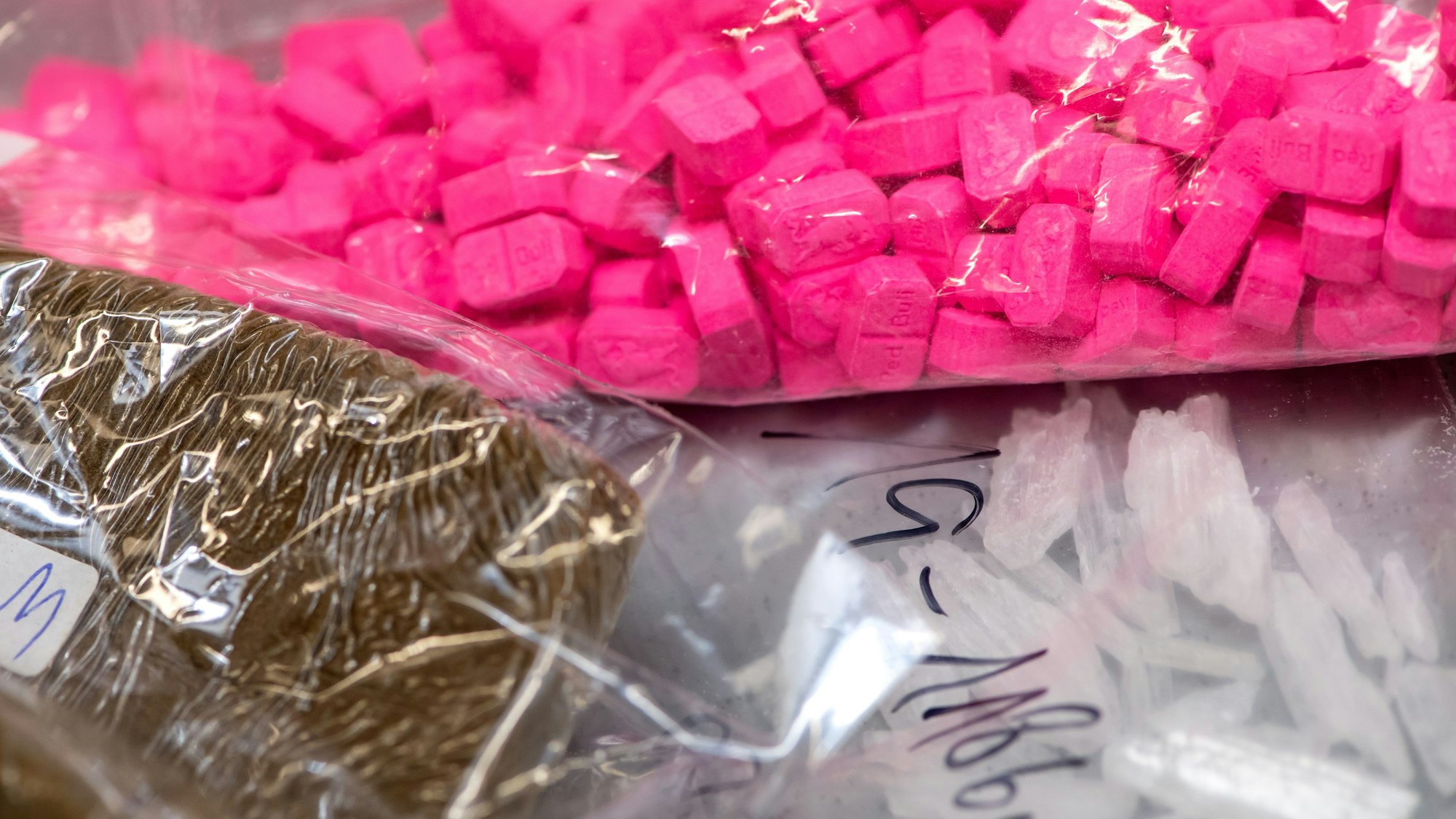 Haschisch (vorne links), Ecstasy (oben) und Crystal liegen in einem Labor auf einem Tisch.