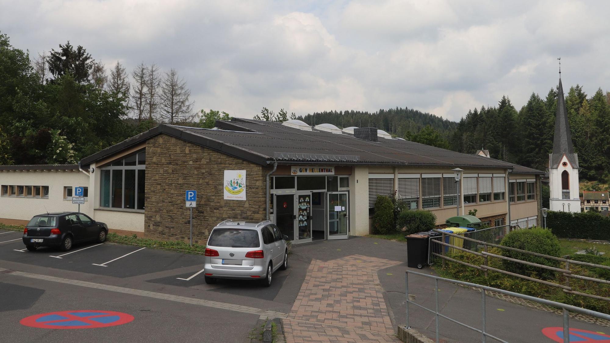 Die Grundschule Hellenthal ist im Vordergrund zu sehen, im Hintergrund ein Kirchturm.