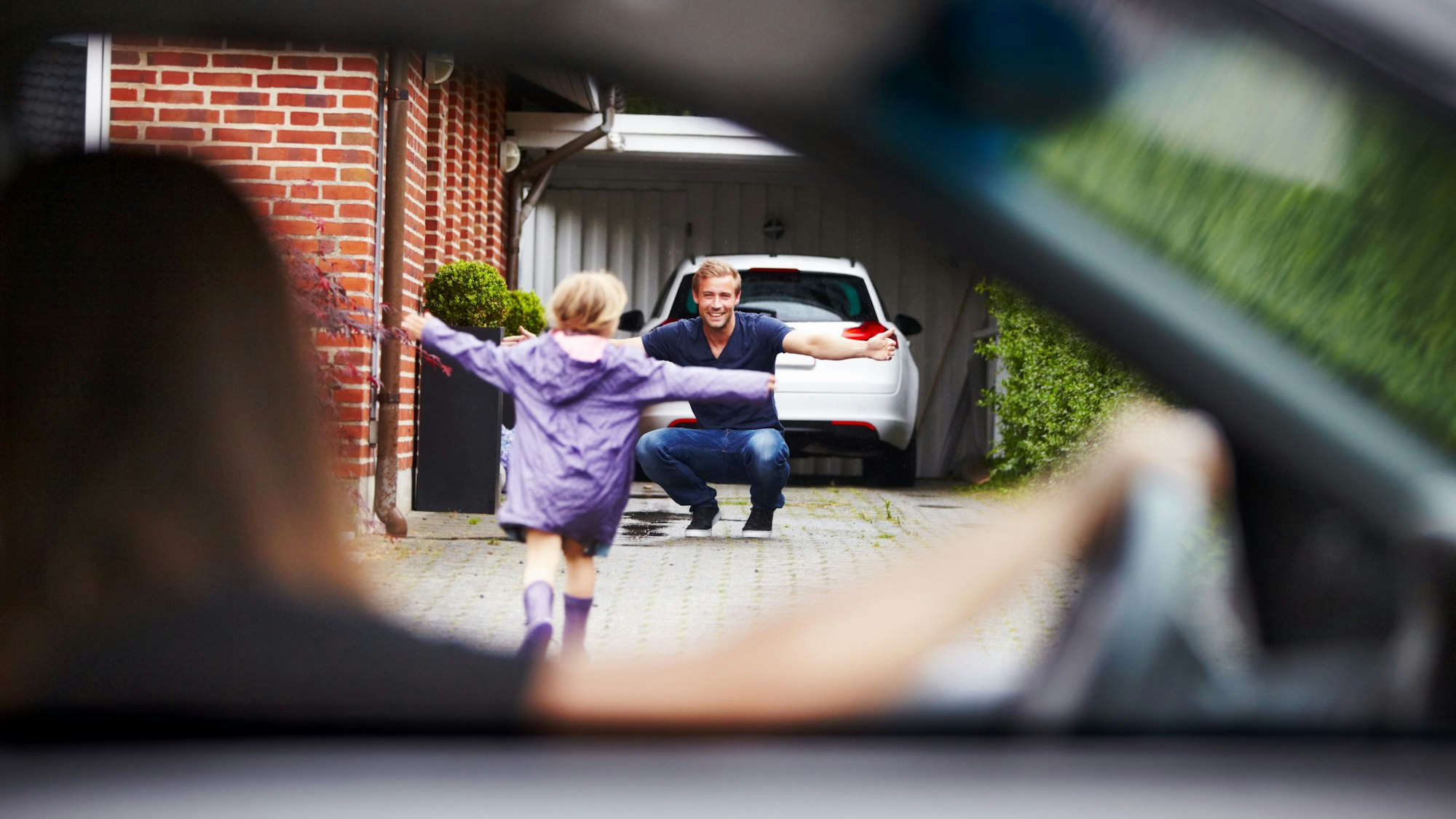Ein kleines Mädchen stürmt auf seinen Vater zu.