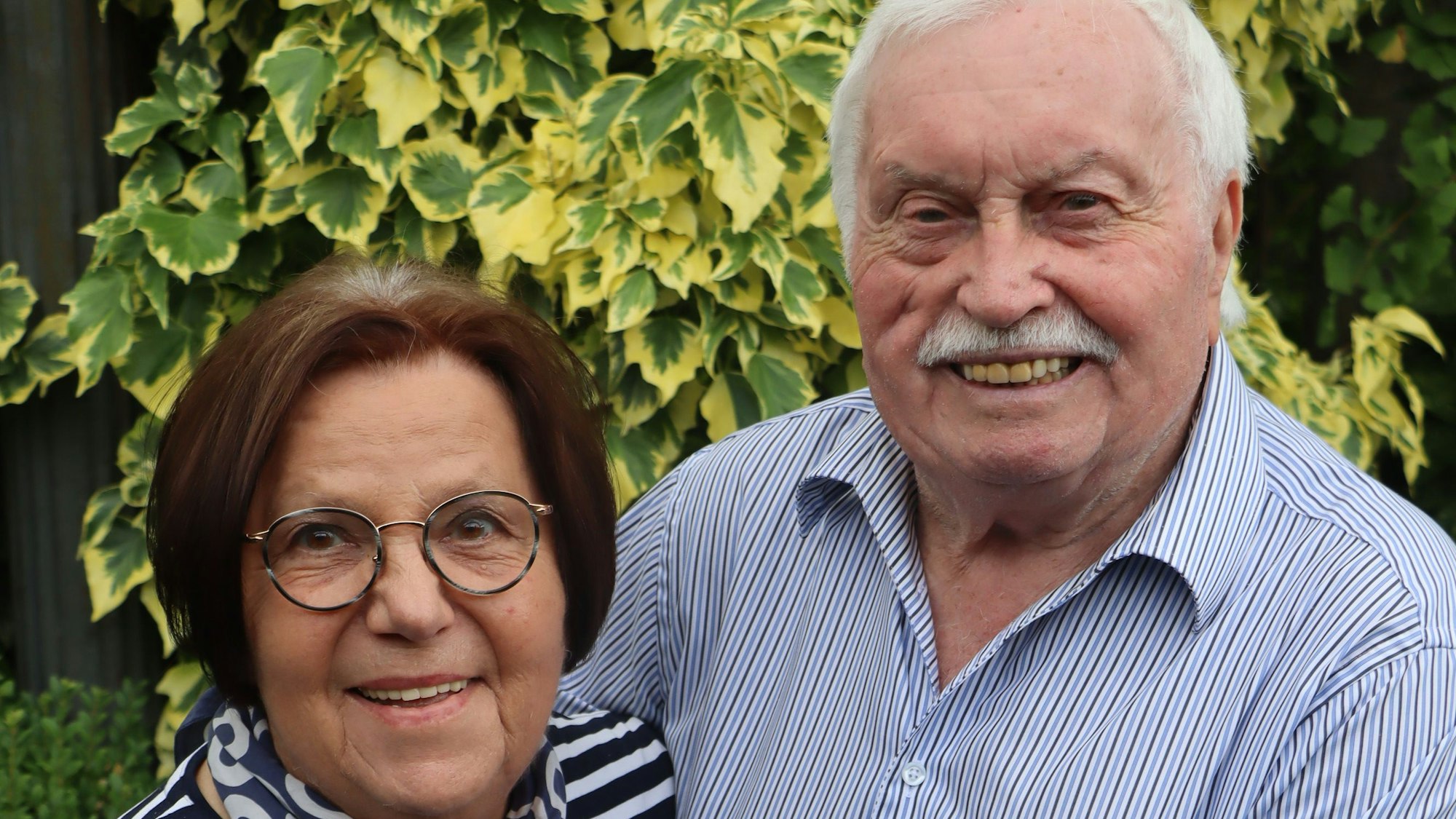Ein älteres Paar lächelt in die Kamera.