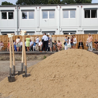 Spaten stecken in einem Sandhaufen für den symbolischen Baubeginn des Bildungscampus Neuenhof