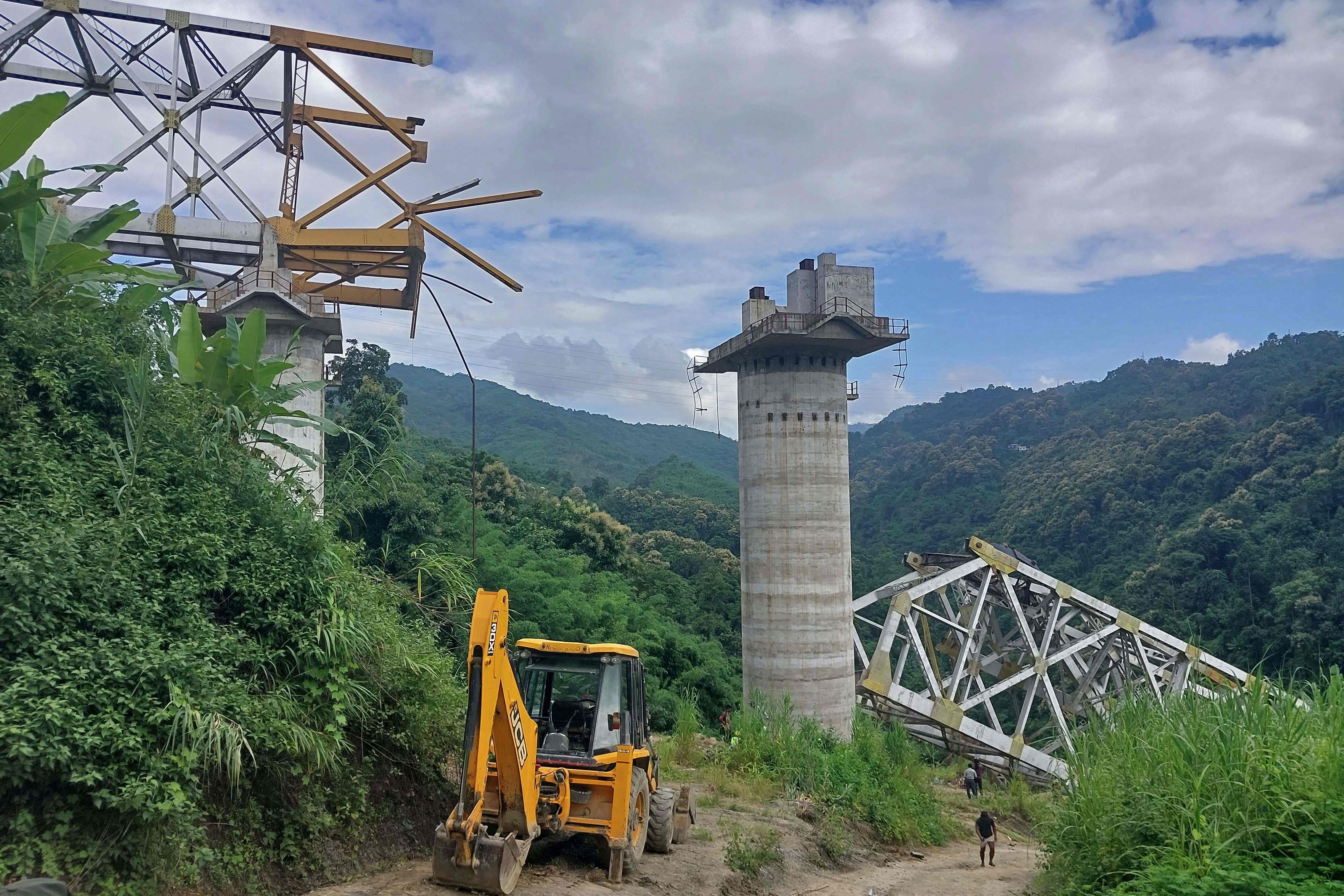 afpRescue workers conduct a search operation at the site of an accident where an under-construction railway bridge collapsed in Sairang town of the Aizwal district in India's eastern state of Mizoram. At least 17 labourers working on a railway bridge being built across a ravine in India's eastern Mizoram state were killed when it collapsed on August 23, officials said, with others reported missing. (Photo by AFP)