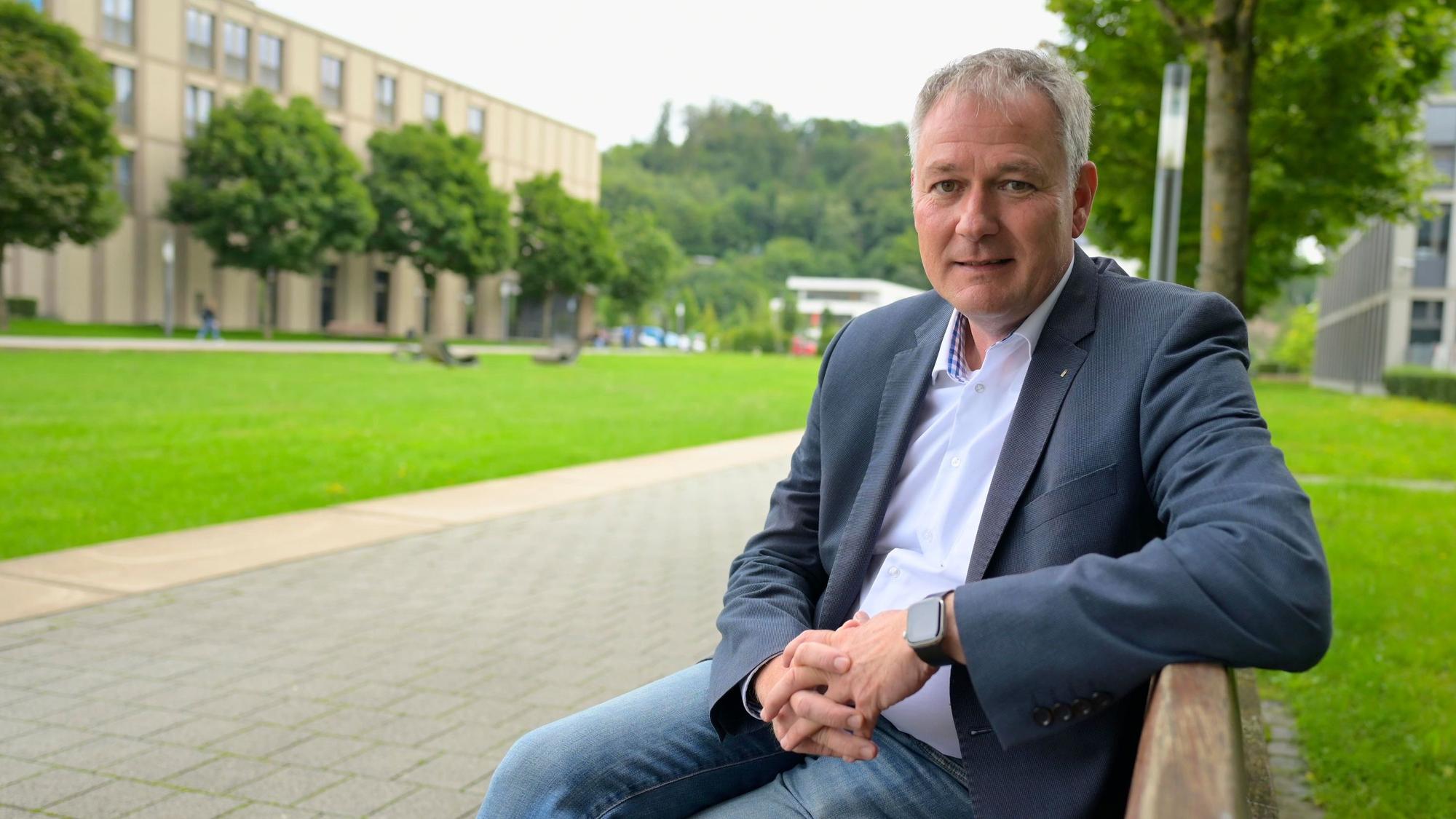 Carsten Bordesser sitzt auf einer Bank.