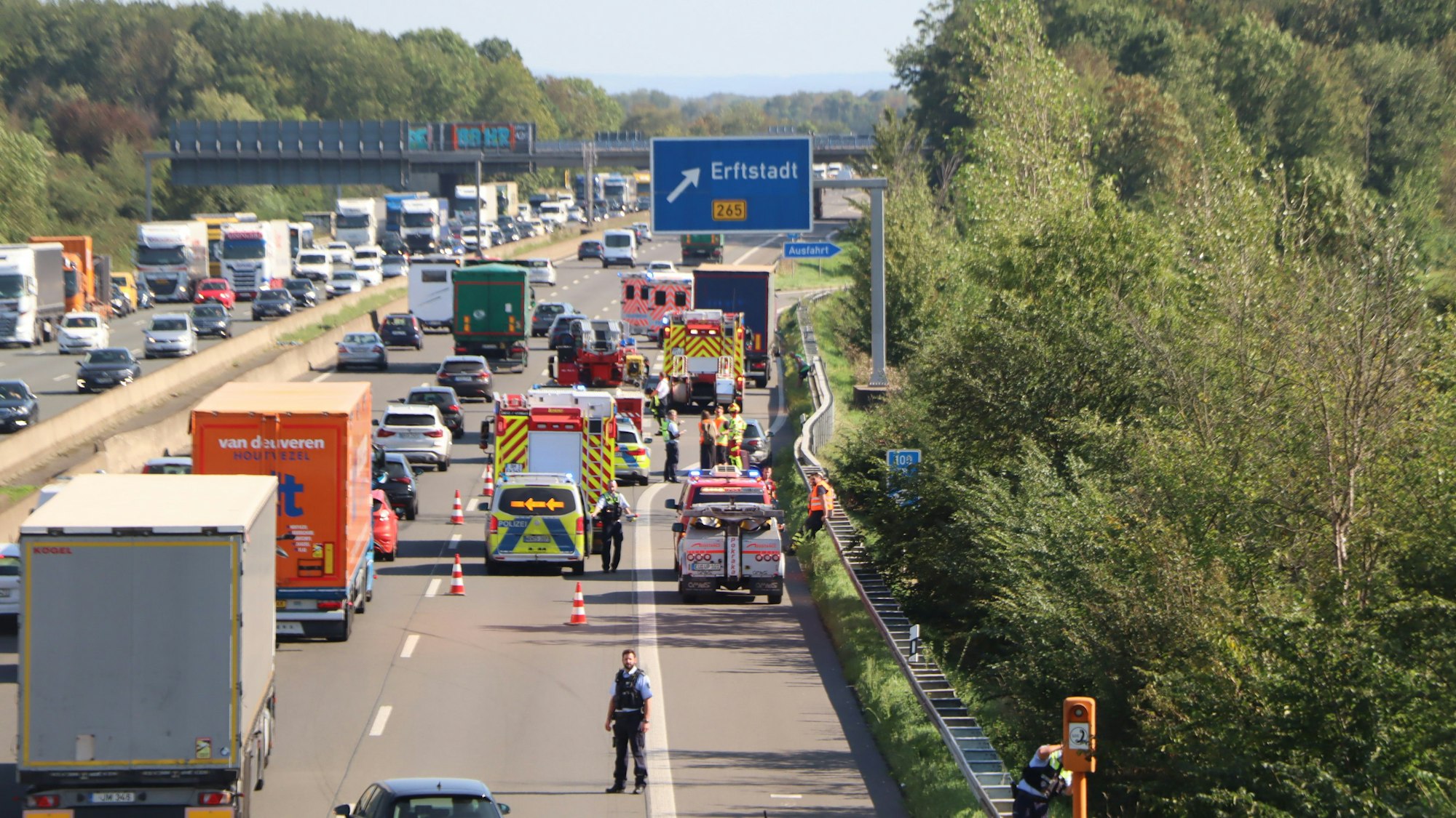 Einsatzkräfte der Polizei und Rettungskräfte kümmern sich nach dem Unfall auf der A1/A61 um die Verletzten.