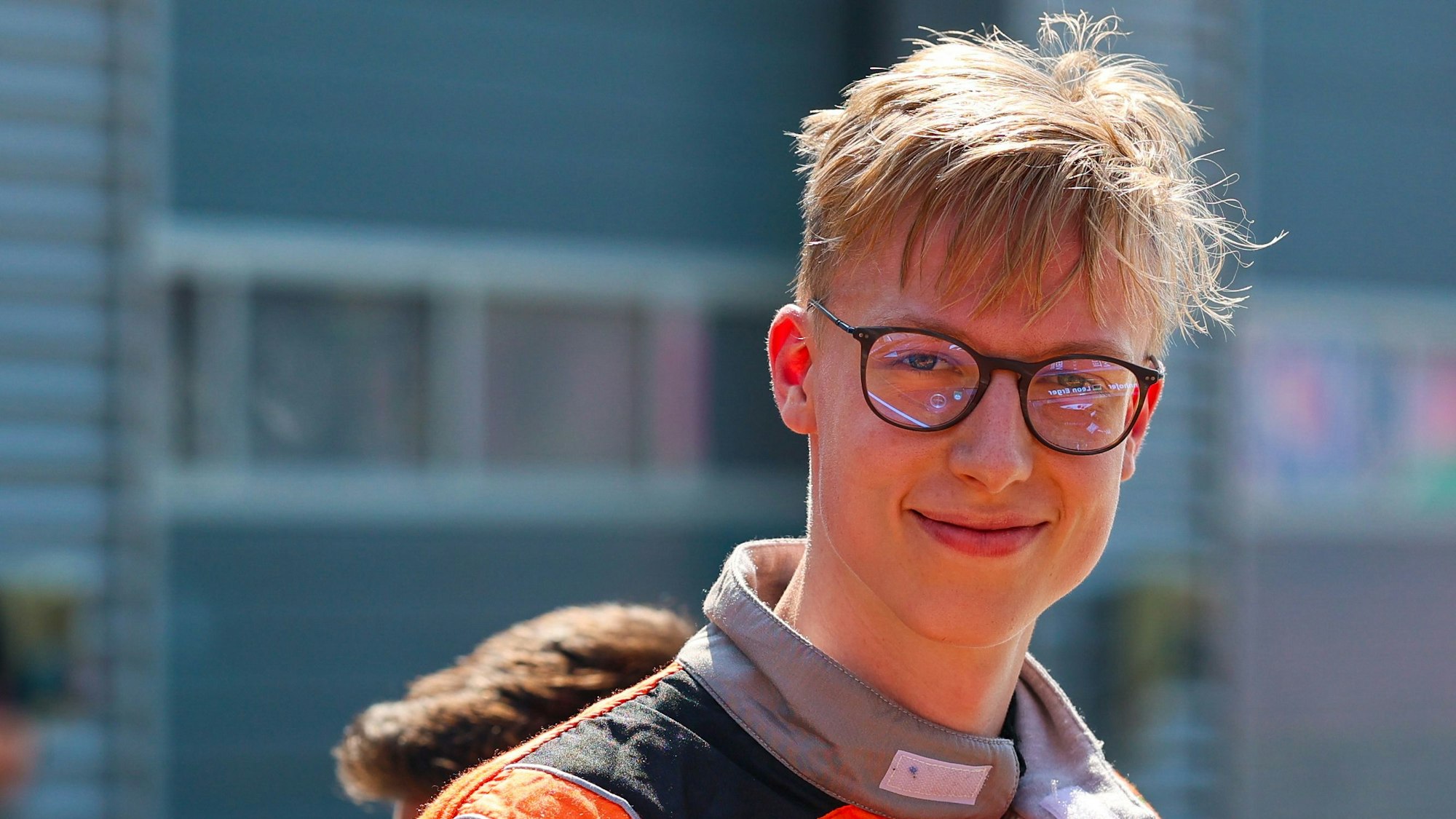 Zu sehen ist ein junger Rennfahrer in seinem Rennanzug.