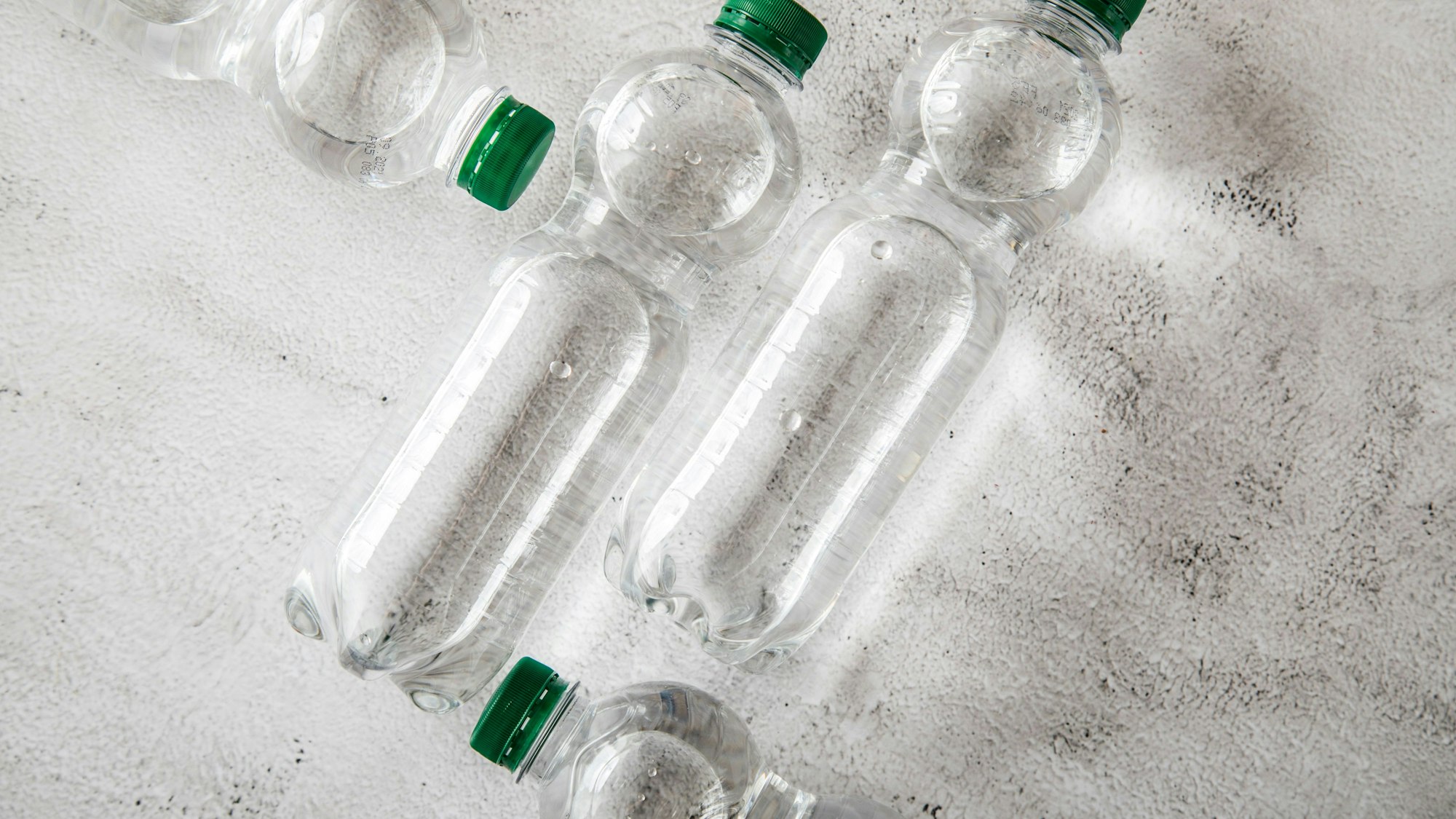 Sy,mbolbild: Vier Wasserflaschen liegen auf dem Boden.