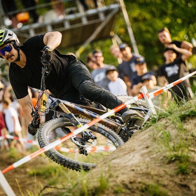 Erster E-Mountainbike-Fahrer nimmt eine Kurve auf der abgesteckten Strecke.