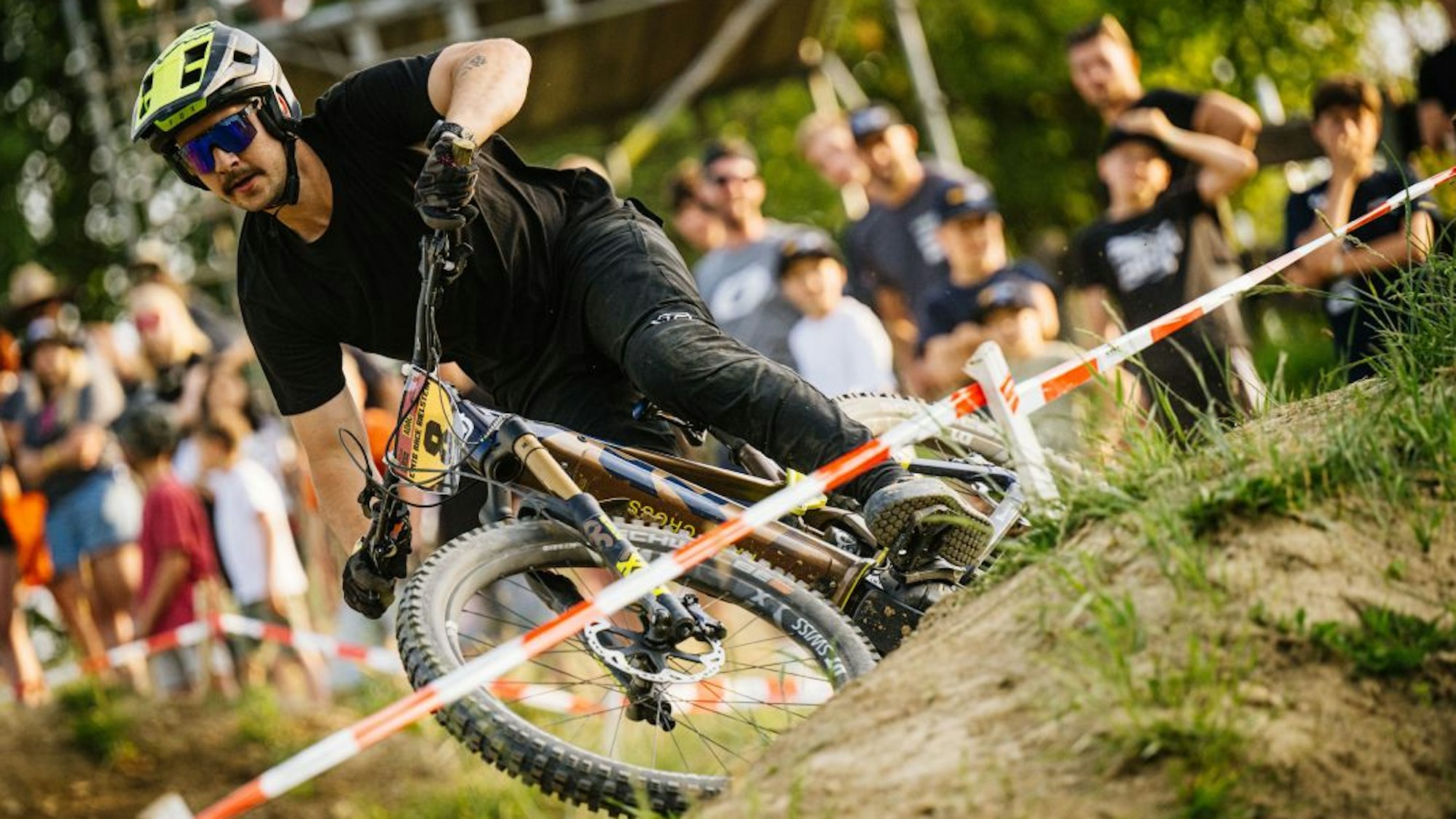 Erster E-Mountainbike-Fahrer nimmt eine Kurve auf der abgesteckten Strecke.