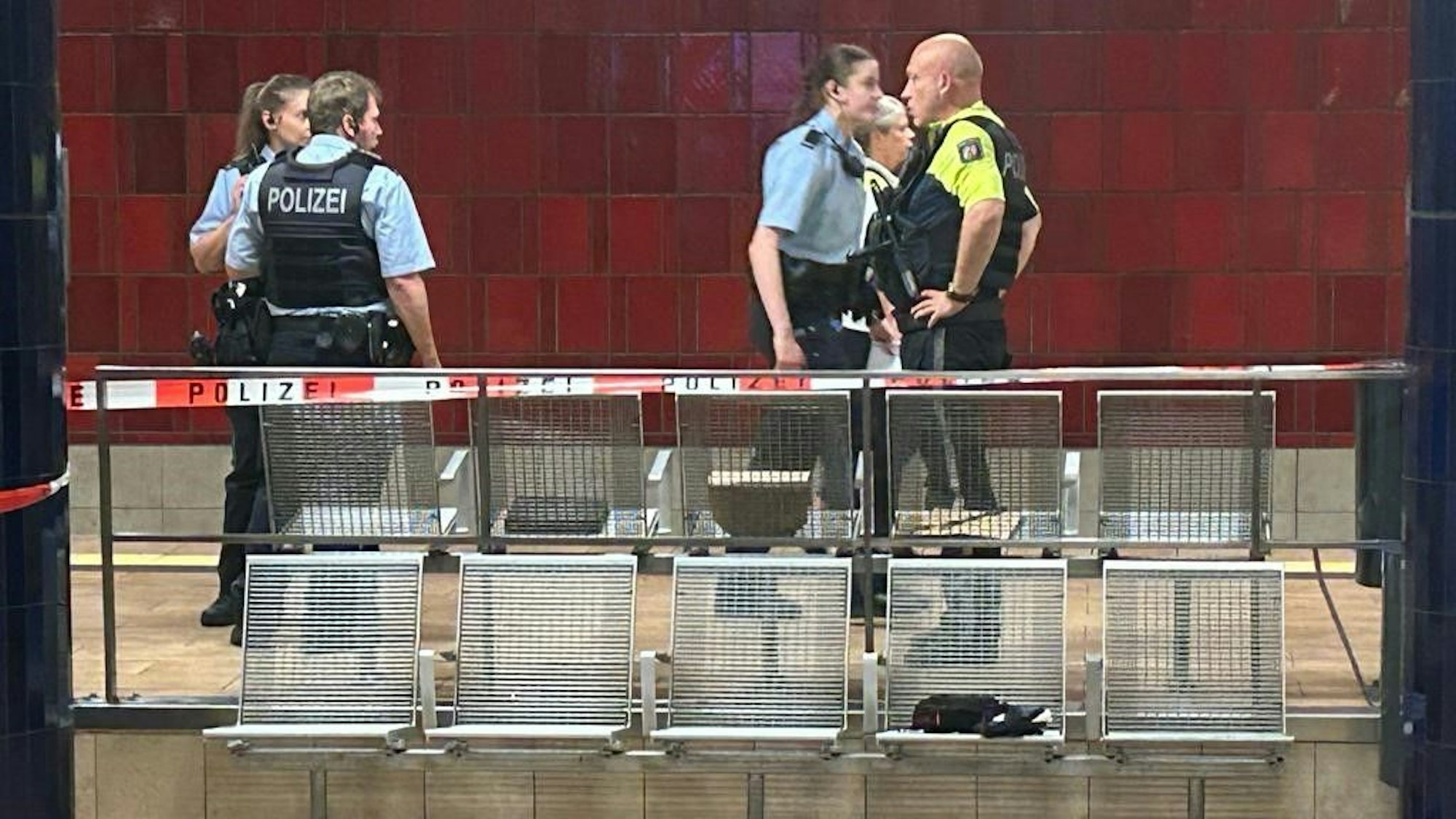 Mehrere Polizisten stehen am Bahnsteig.