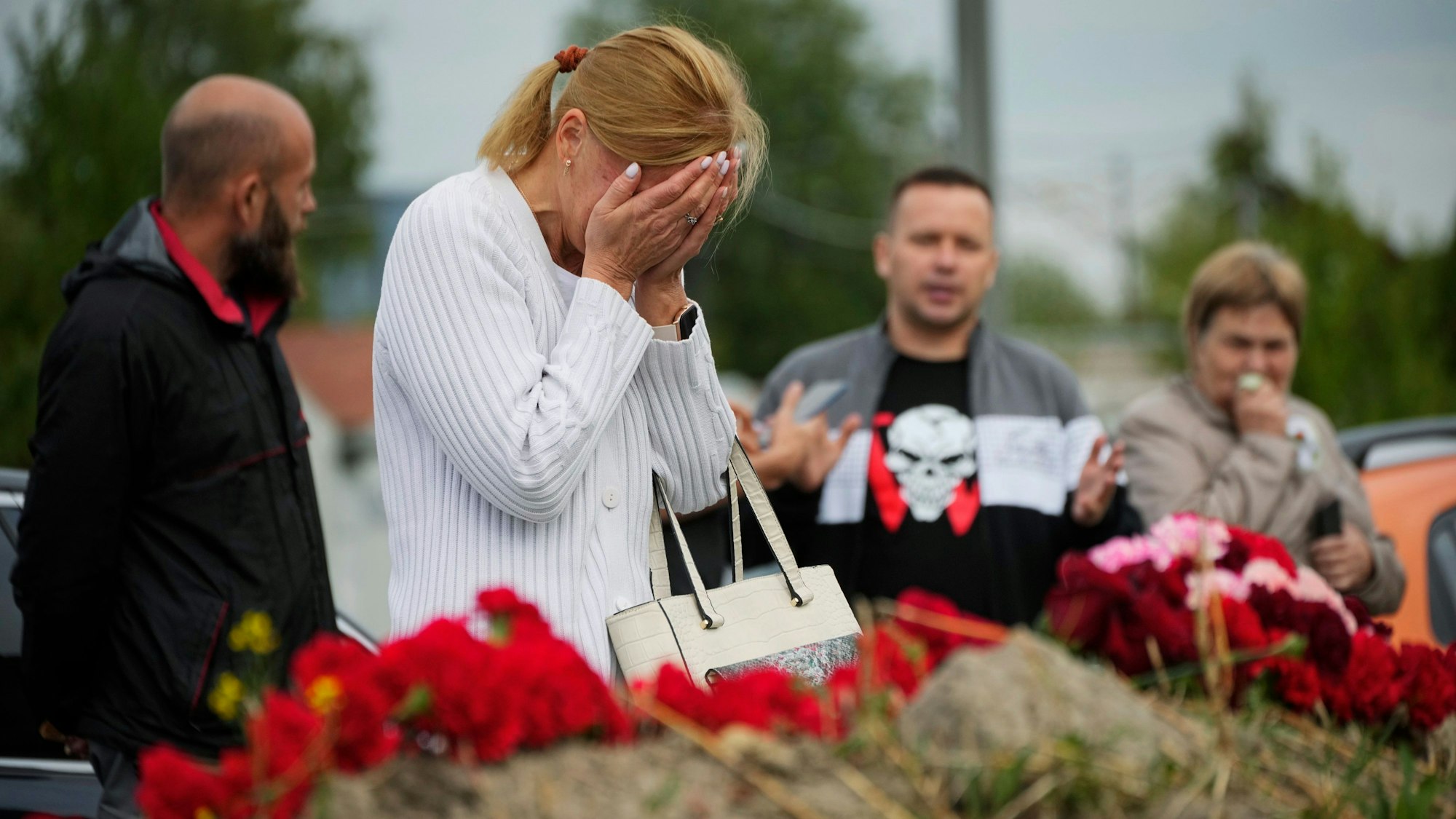 A woman reacts at an informal memorial next to the former 'PMC Wagner Centre' in St. Petersburg, Russia, Thursday, Aug. 24, 2023. Russian mercenary leader Yevgeny Prigozhin, the founder of the Wagner Group, reportedly died when a private jet he was said to be on crashed on Aug. 23, 2023, killing all 10 people on board. (AP Photo/Dmitri Lovetsky)