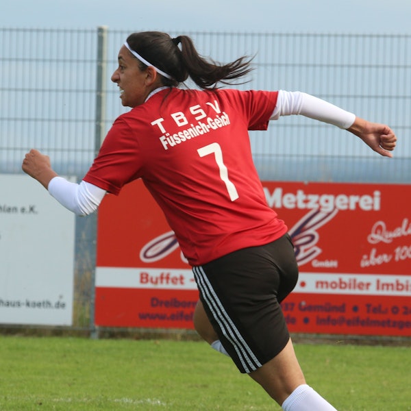 Das Bild zeigt eine Fußballerin, die nach einem Torerfolg jubelnd abdreht.
