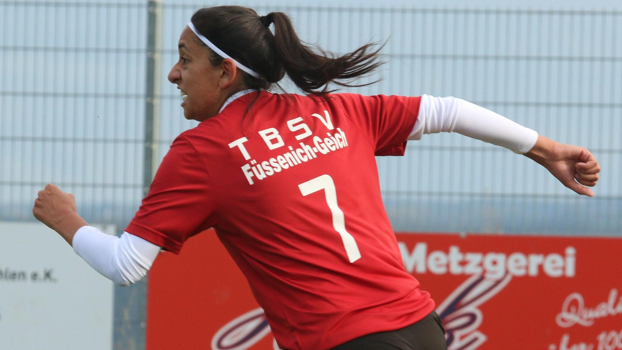 Das Bild zeigt eine Fußballerin, die nach einem Torerfolg jubelnd abdreht.