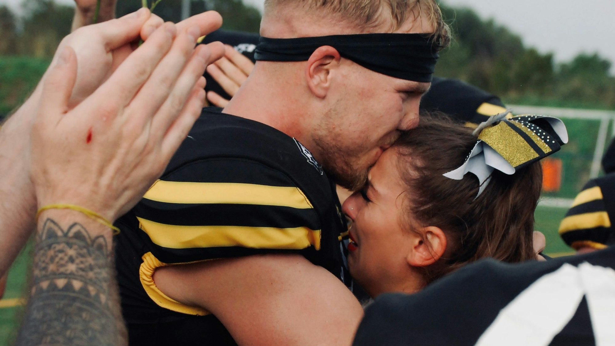 Das Bild zeigt Robin Skorwider, wie er seine Freundin Mariana Asenova auf die Stirn küsst.