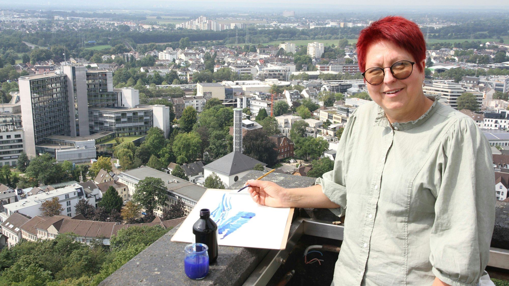 Künstlerin Katharina Krenkel mit Zeichenutensilien auf der Aussichtsplattform des Siegburger Abteiturms