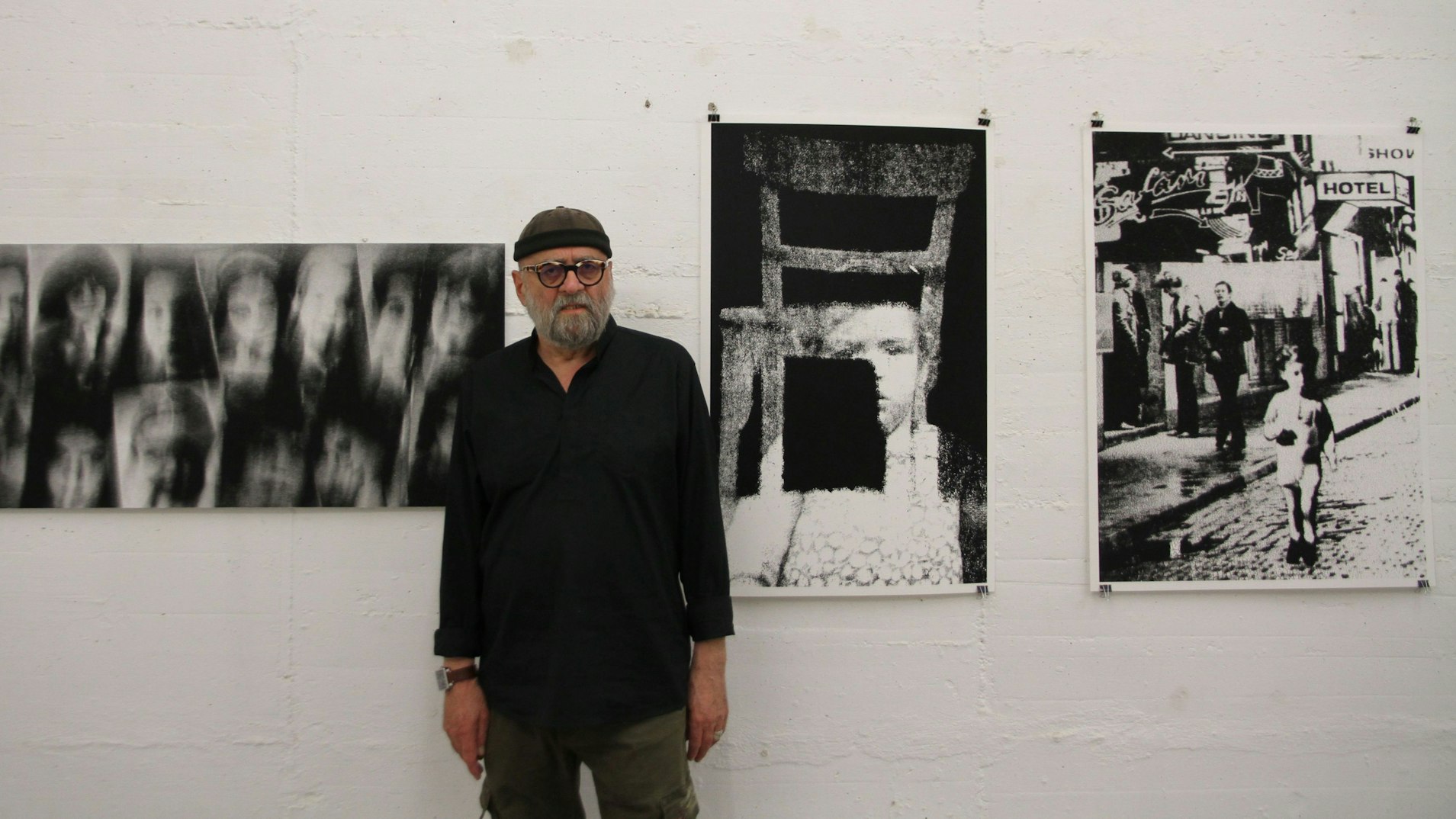 Ein Mann steht vor Schwarz-Weiß-Fotografien, die Kinder zeigen