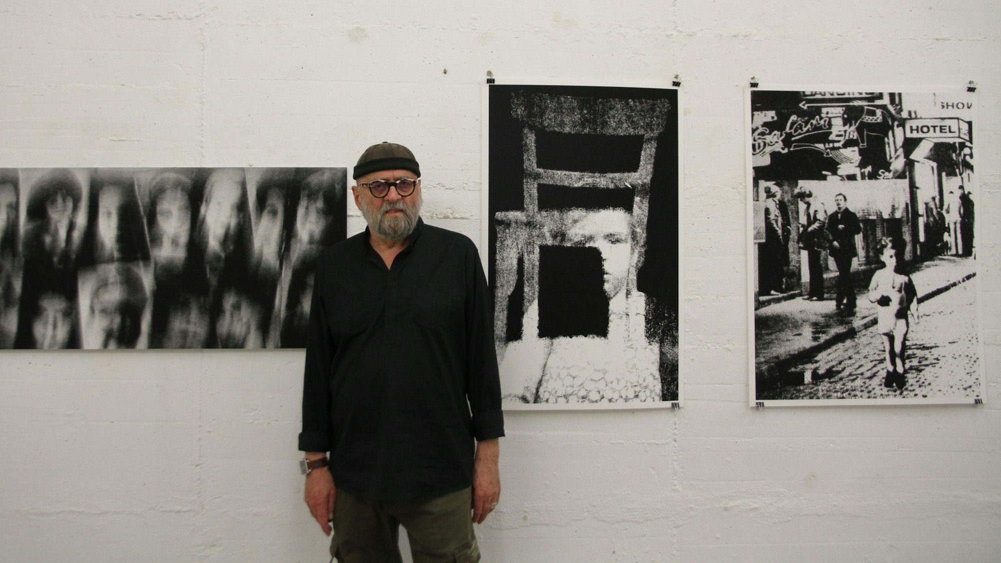 Ein Mann steht vor Schwarz-Weiß-Fotografien, die Kinder zeigen