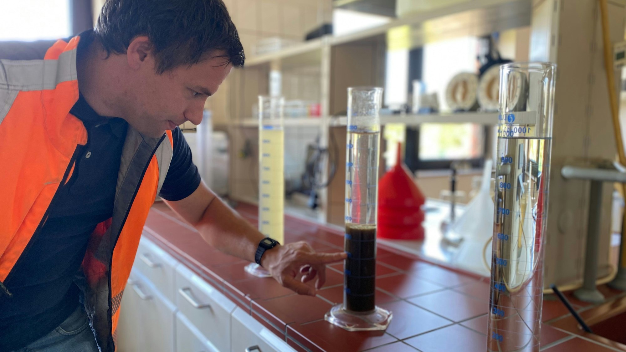 Auf einem Tisch stehen drei Reagenzgläser. In einem befindet sich eine trübe Flüssigkeit. In einem hat sich eine schlammige Masse abgesetzt, darüber ist das Wasser klar. Im dritten befindet sich nur klares Wasser.