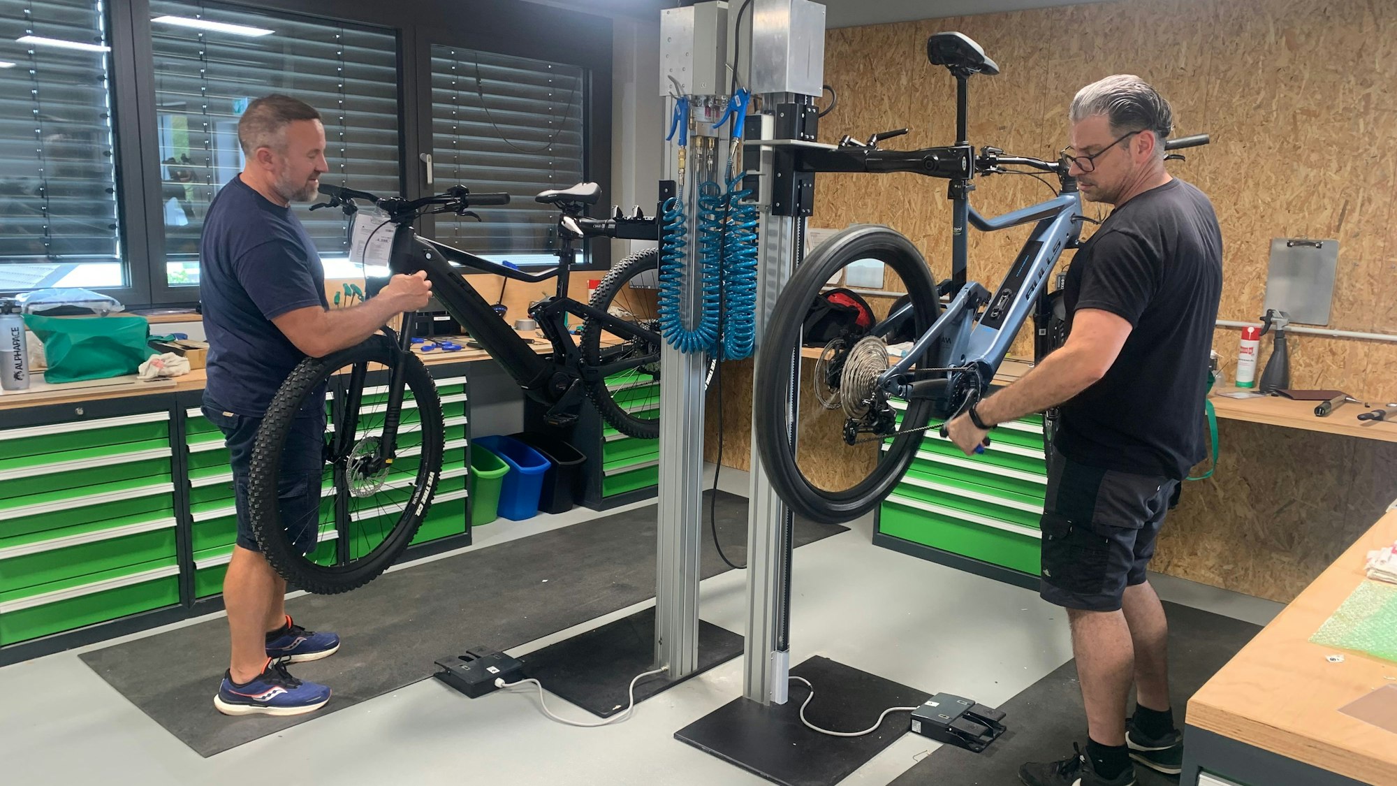Zwei Mechatroniker montieren E-Bikes zusammen, die in Teilen aus der Fabrik in den Laden in Sankt Augustin geliefert werden..