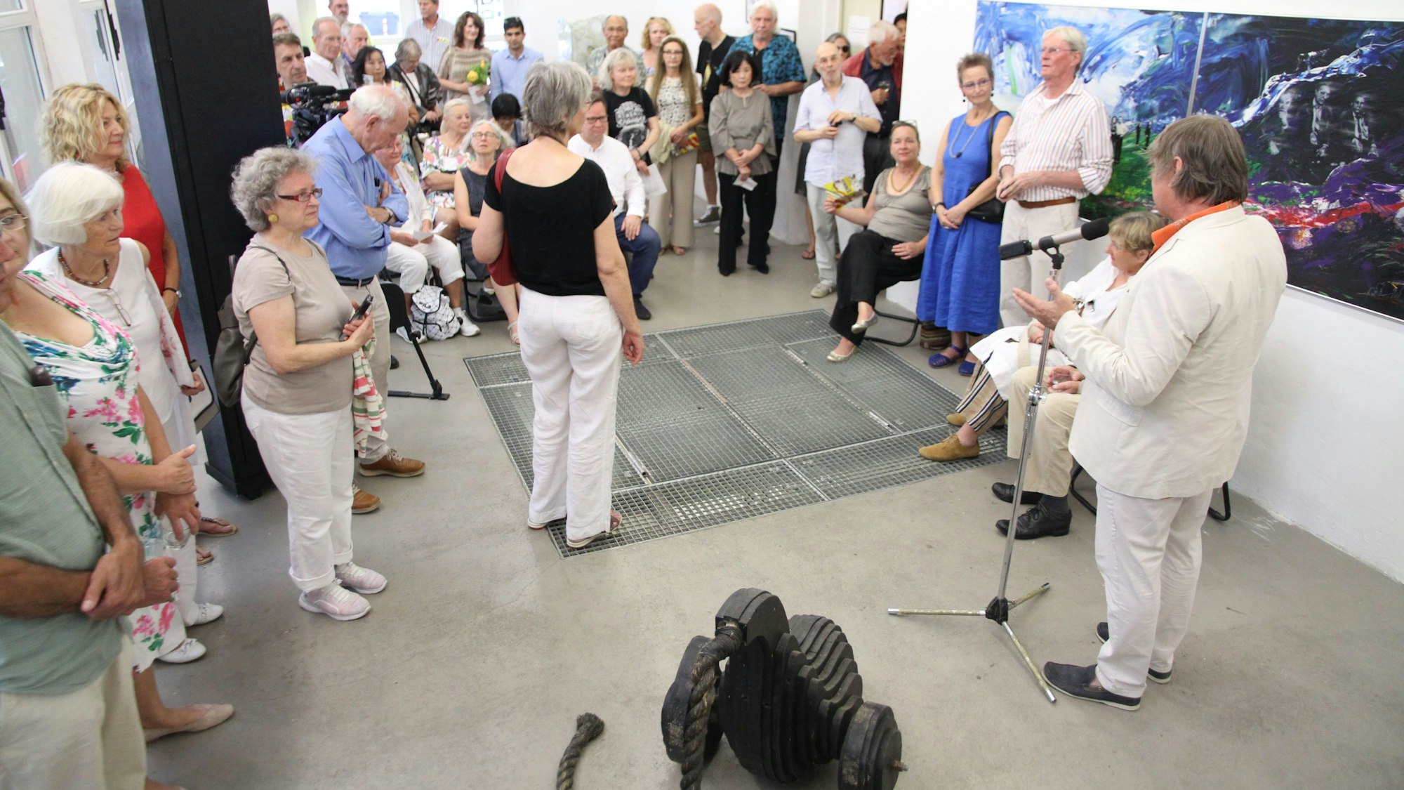 Eine Gruppe von Menschen steht in einem Raum mit verschiedenen Kunstwerken