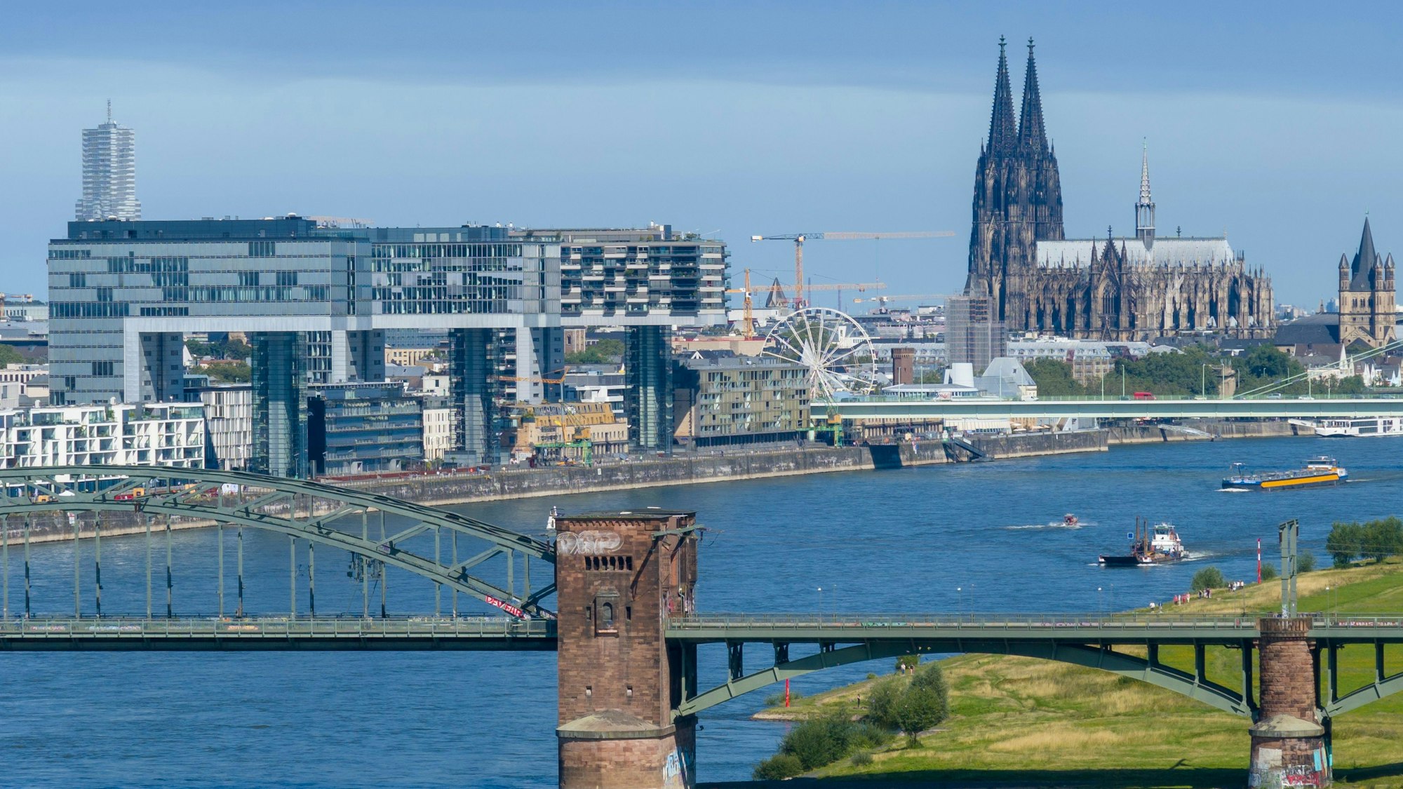 Blick über den Rhein in Köln mit dem Kölner Dom und den Kranhäusern im Hintergrund.