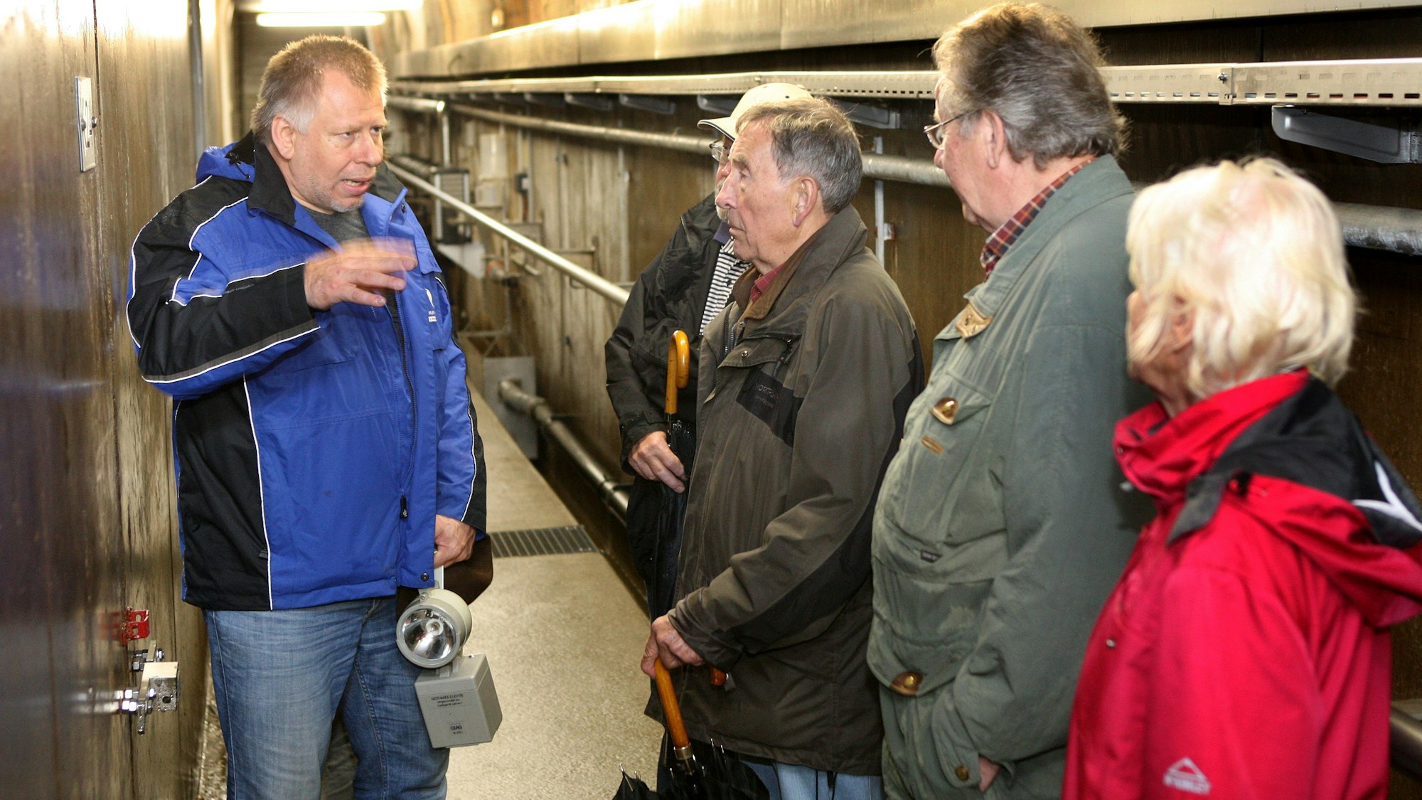 Ein Mitarbeiter des Wupperverbands erläutert Teilnehmern einer Führung das Innere des Kontrollgangs im Staudamm der Großen Dhünn-Talsperre.