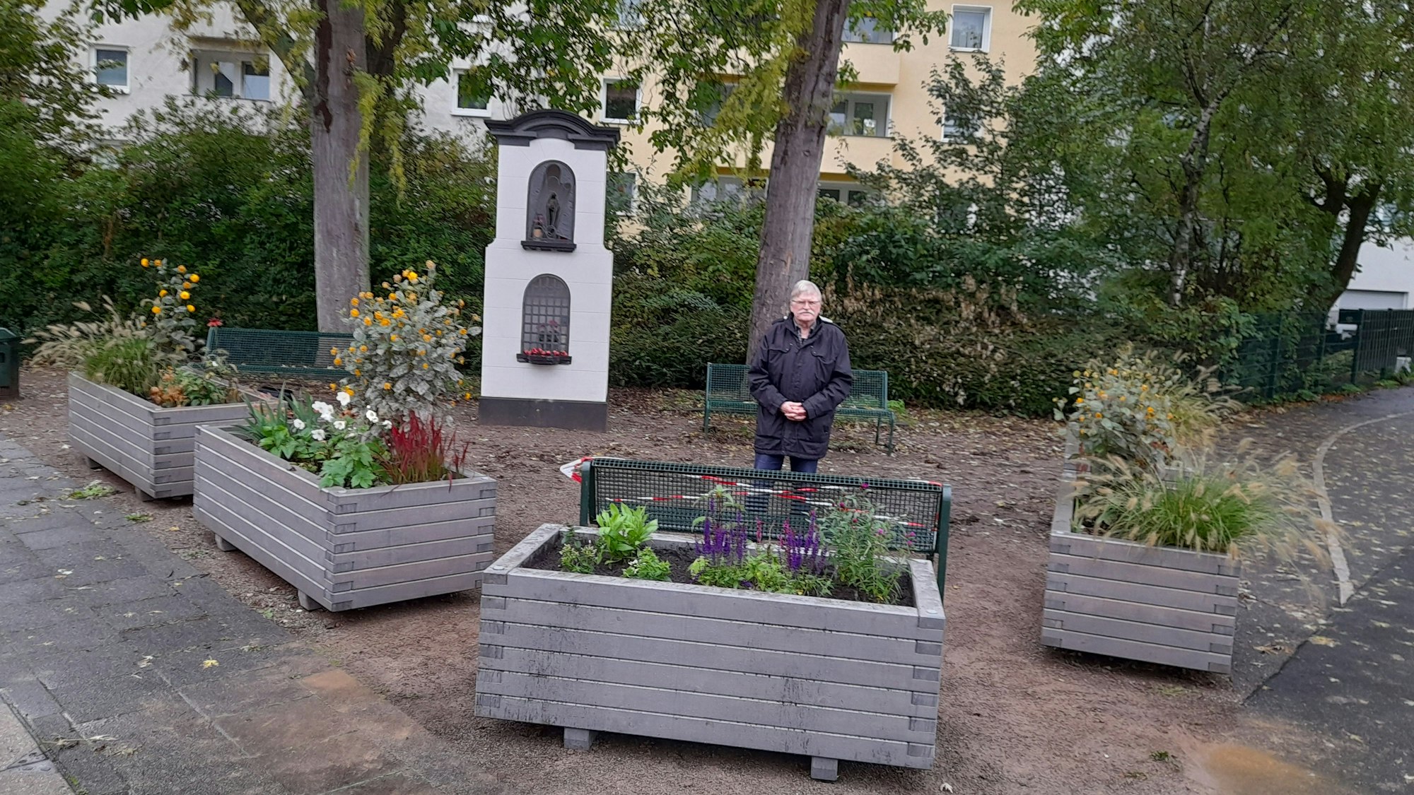 Dr. Herbert Clasen steht auf dem fertigen Platz vor dem Bildstock.
