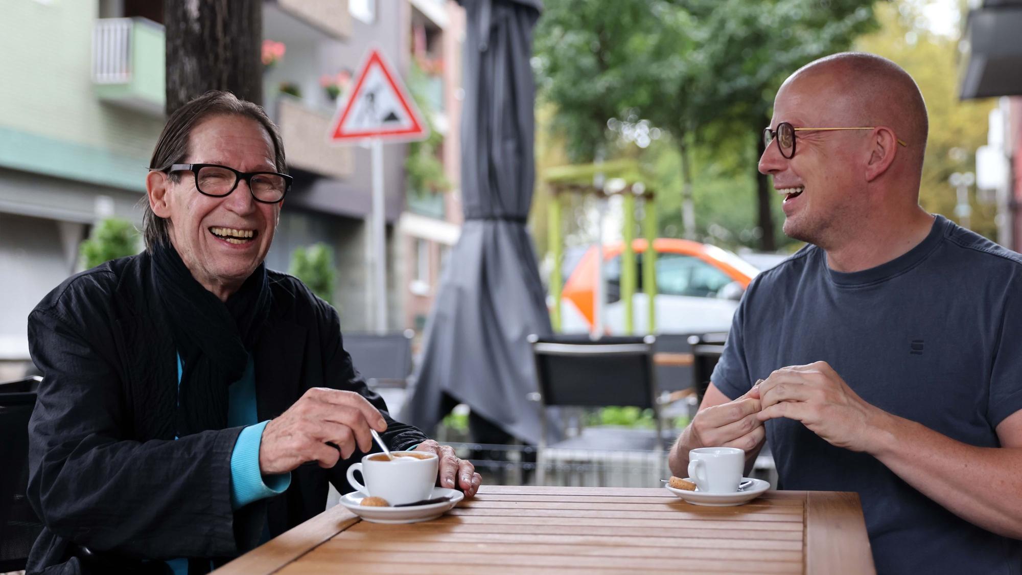 Zwei Männer trinken Kaffee.