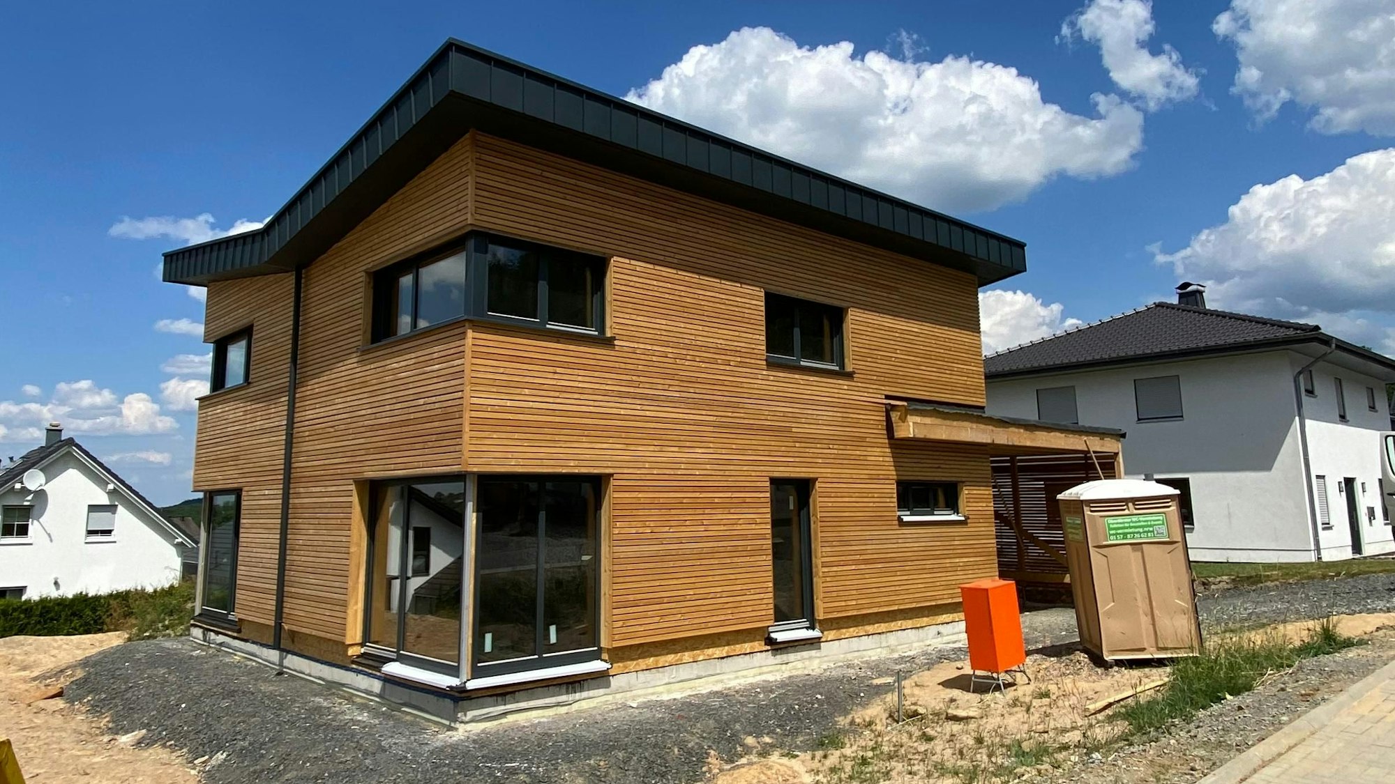 Ein Neubaugebiet mit einem modernen Holzhaus.