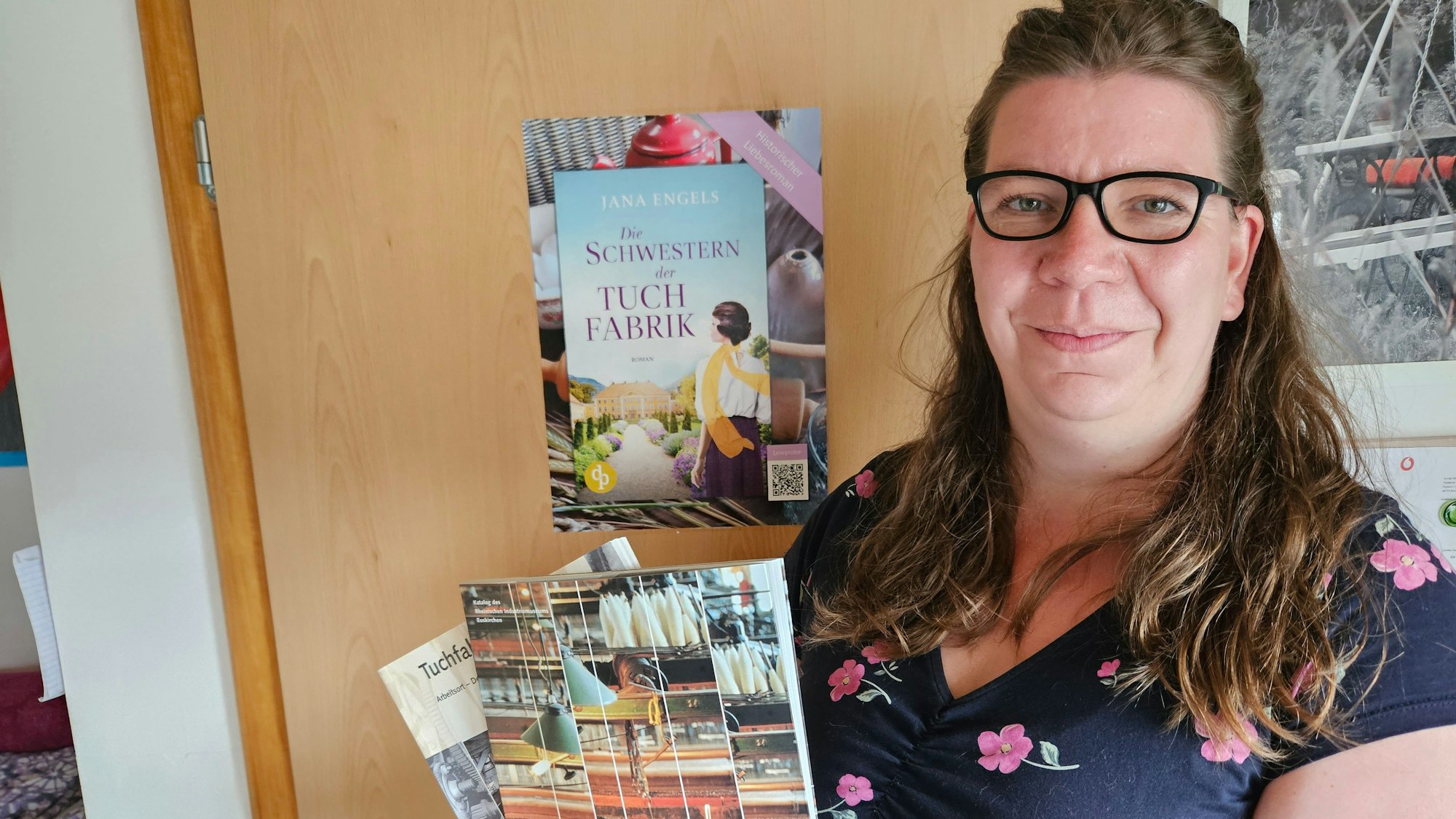 Die Autorin steht vor einem Plakat mit ihrem neuen Buch.