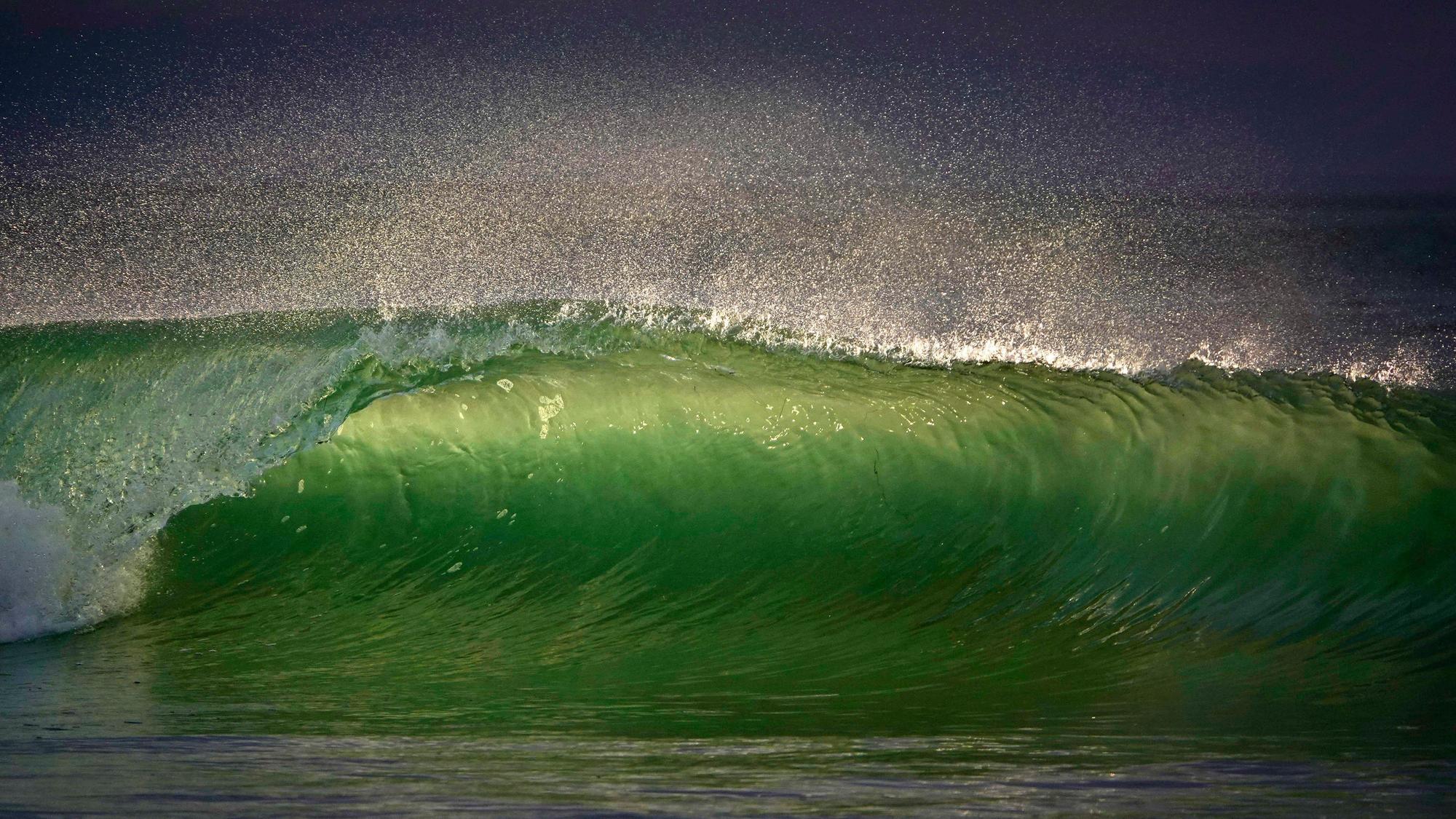 Eine Welle bricht, während die Sonne am Windansea Beach in der Gemeinde La Jolla in San Diego untergeht.