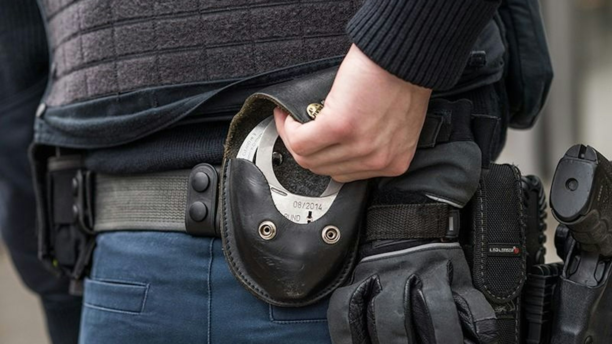 Ein Bundespolizist zieht Handschellen, um einen Verdächtigen oder eine Verdächtige festzunehmen. (Symbolbild)