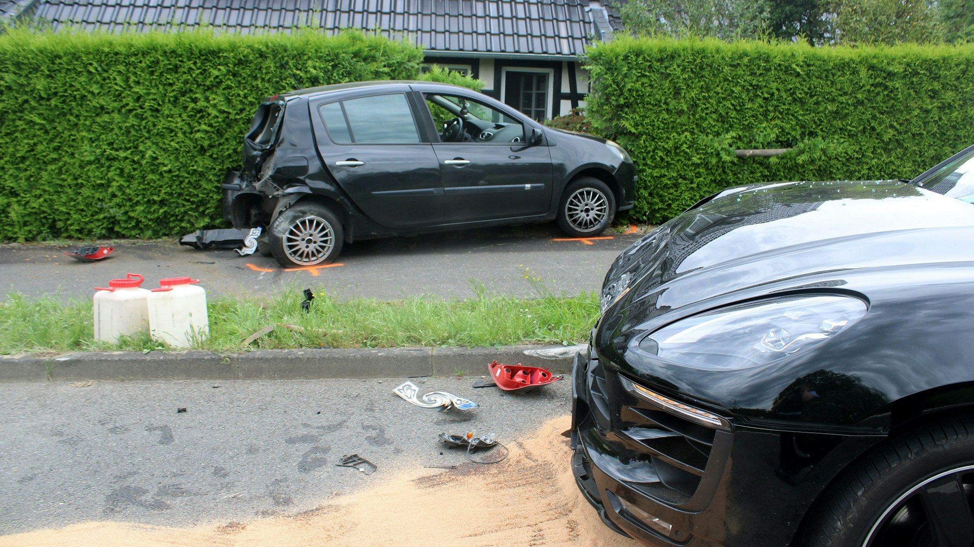 Zwei Unfallfahrzeuge stehen nach einem Zusammenstoß auf und neben einer Straße.