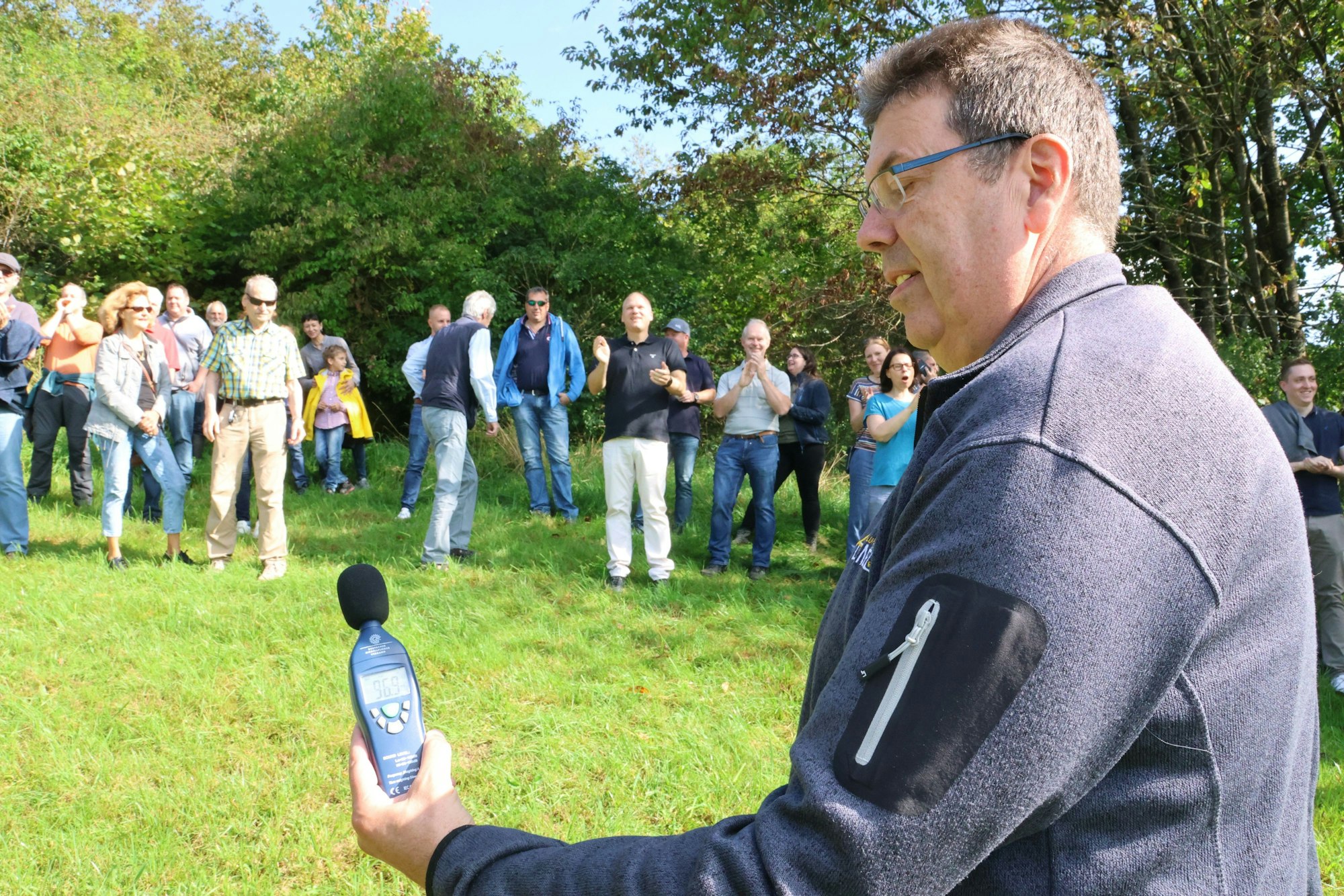 Unterwegs zücken die Teilnehmenden immer wieder technische Geräte: Hier misst Achim Lorenz aus Eckenhagen den Lärmpegel, der vom Johlen und Klatschen der Gruppe auf der Ballonwiese ausgeht.