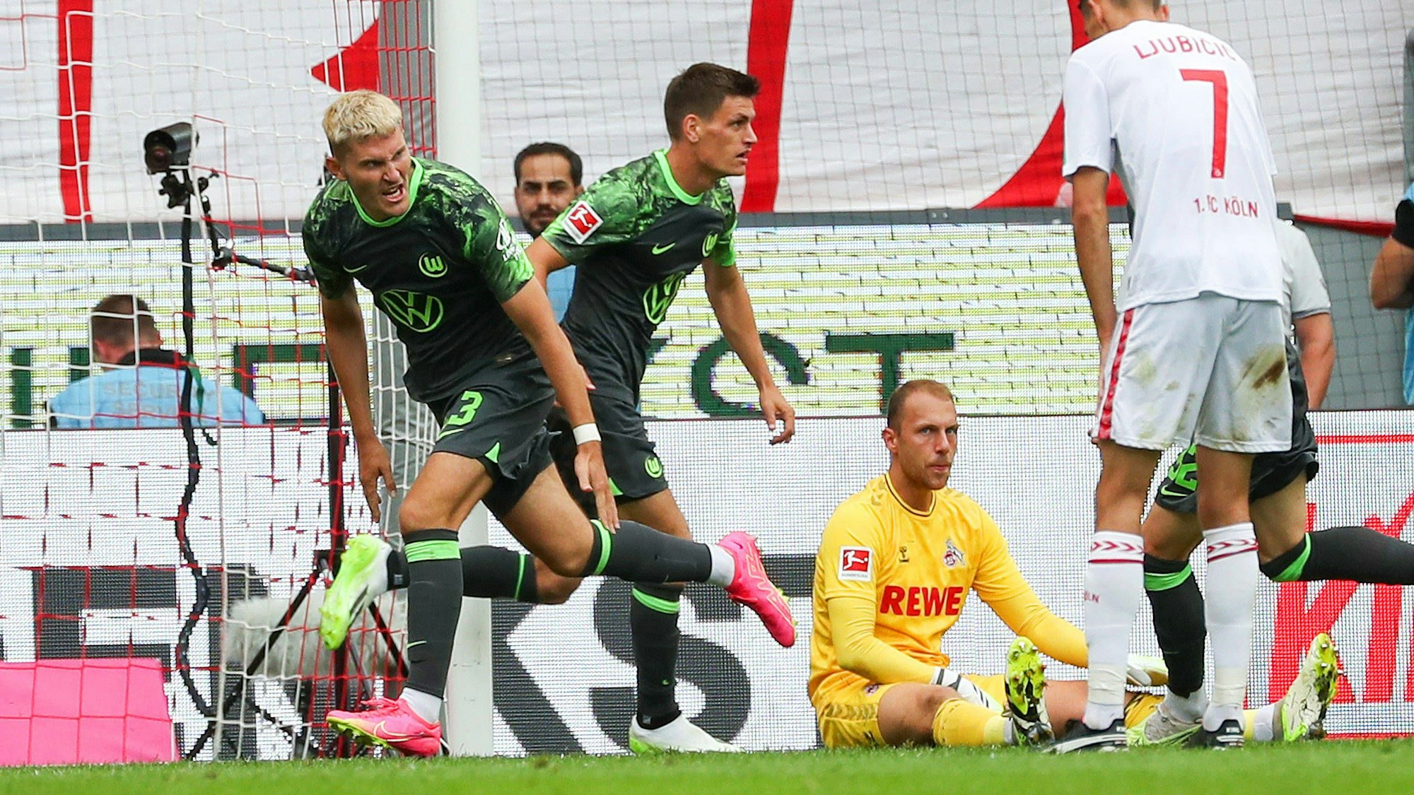Köln vs. VfL, 1. BL Köln, 26.08.2023, FUßBALL - 1. FC Köln vs. VfL Wolfsburg, 1. BL, Saison 2023/24. Jonas Wind VfL Wolfsburg jubelt mit Mannschaftskollegen nach seinem Tor zum 1:2, Torwart Marvin Schwäbe 1.FC Köln, Dejan Ljubicic