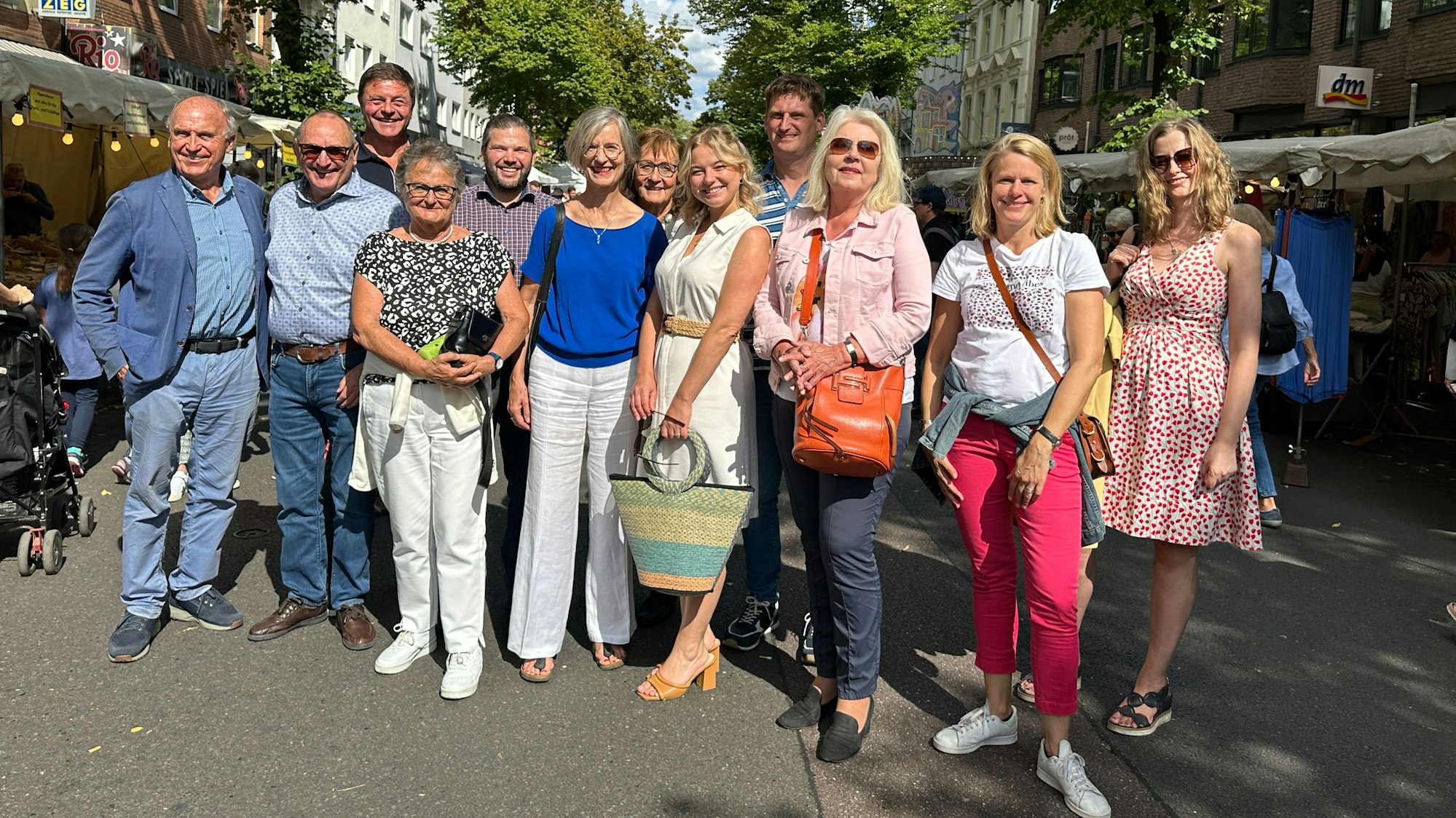 Eine Gruppe Menschen steht zusammen und schaut in die Kamera.