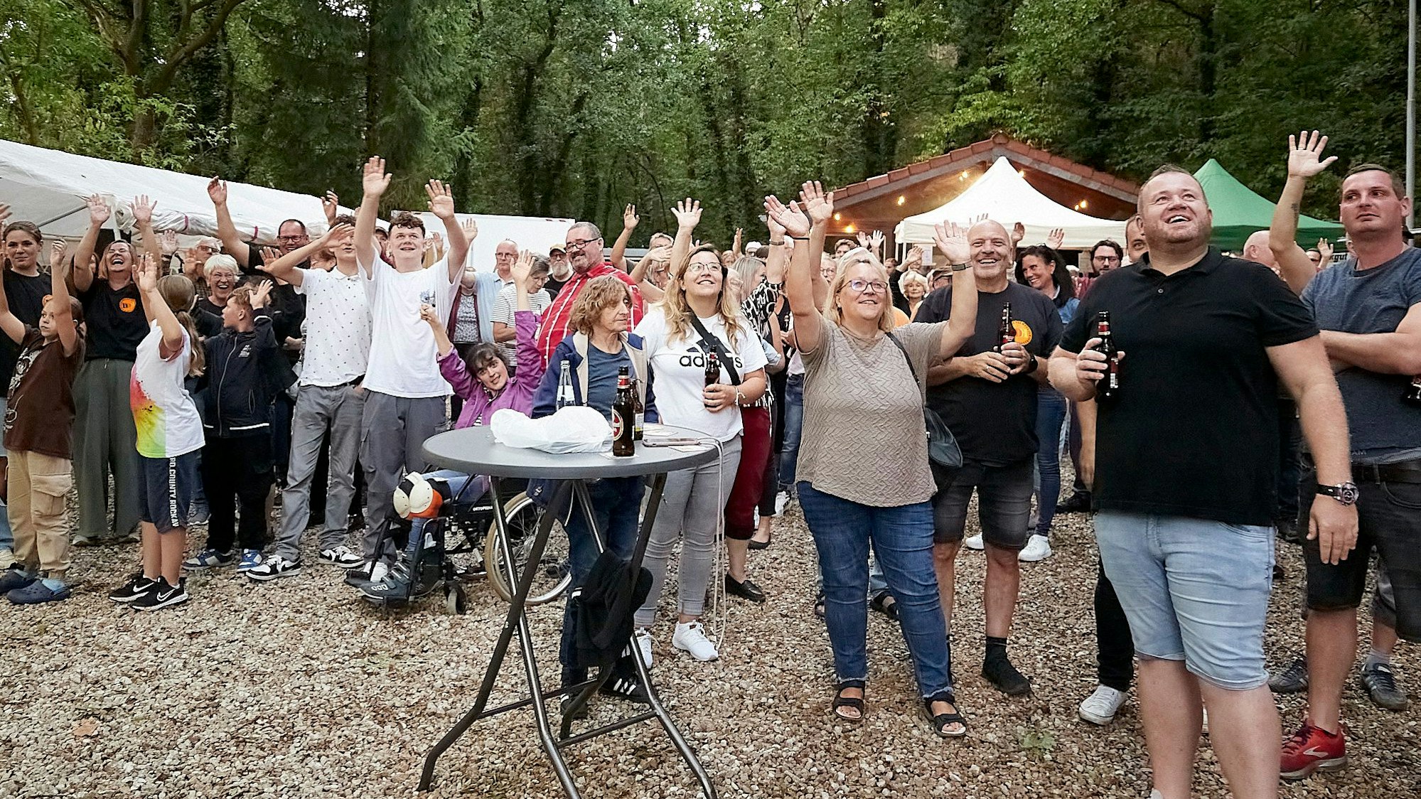 Auf einem Festplatz recken Konzertbesucher ihre Arme in die Höhe, damit sie bei einer Zählung per Drohne registriert werden.