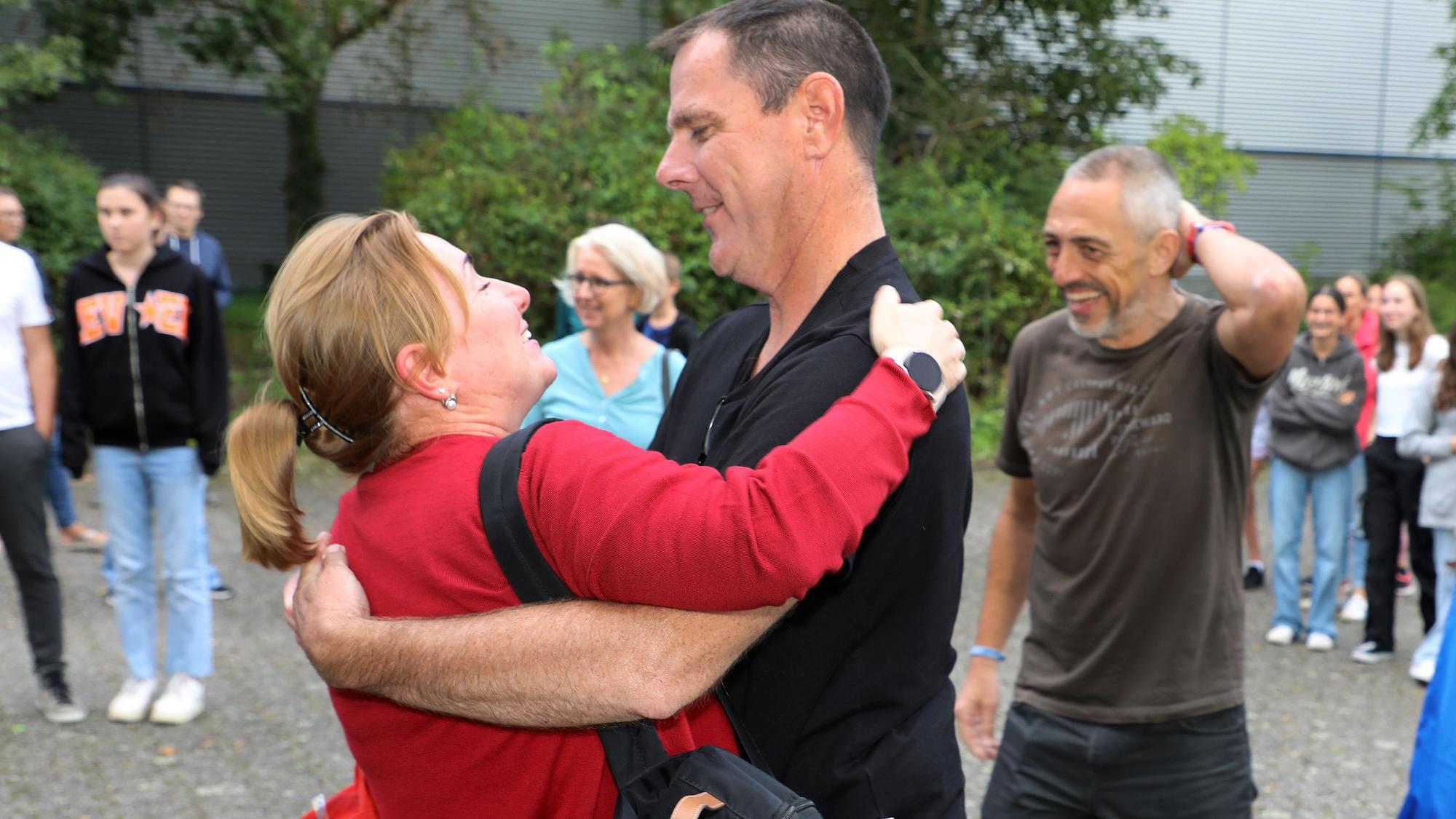 Menschen nehmen sich zur Begrüßung in den Arm.