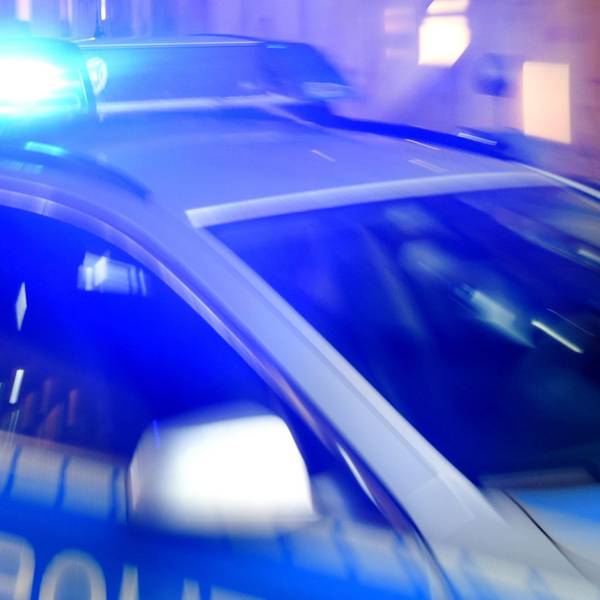 Ein Streifenwagen der Polizei steht mit eingeschaltetem Blaulicht auf der Straße.