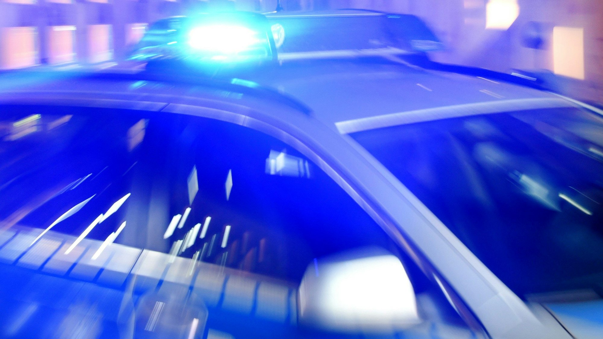 Ein Streifenwagen der Polizei steht mit eingeschaltetem Blaulicht auf der Straße. (Symbolbild)