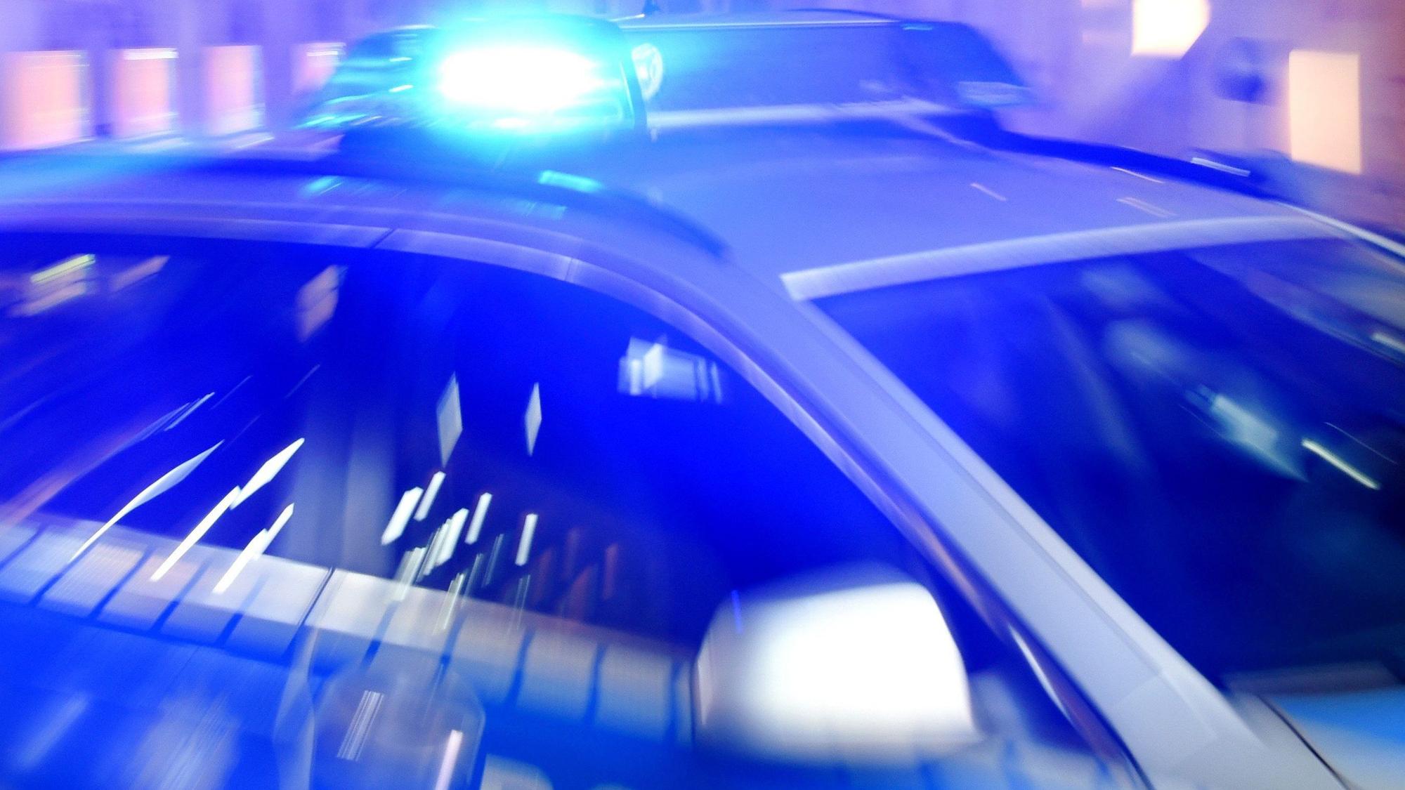 Ein Streifenwagen der Polizei steht mit eingeschaltetem Blaulicht auf der Straße. (Symbolbild)