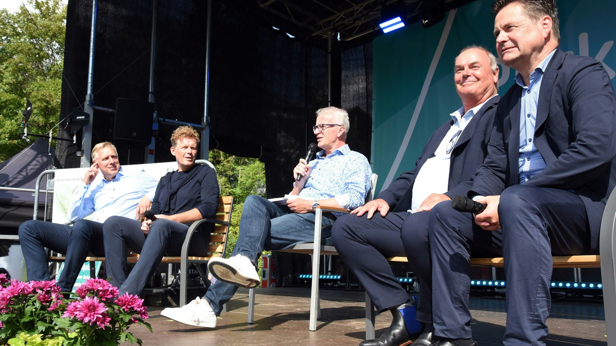 Zum Eröffnungsakt des neugestalteten Wiehlparks gehörte auch ein „Parkgespräch“, an dem Dr. Uwe Moshage (Vorstand Aggerverband, v.l.), Dr. Reimar Molitor (Geschäftsführer der Regionale 2025), Moderator Rainer Kalscheuer (Deutsche Stadt- und Grundstücksentwicklungsgesellschaft), Bartholomäus Labenz (Regierungsbaudirektor der Bezirksregierung Köln) und Wiehls Bürgermeister Ulrich Stücker teilnahmen. Die Männer nahmen dafür auf der Bühne und dort auf Parkbänken Platz.